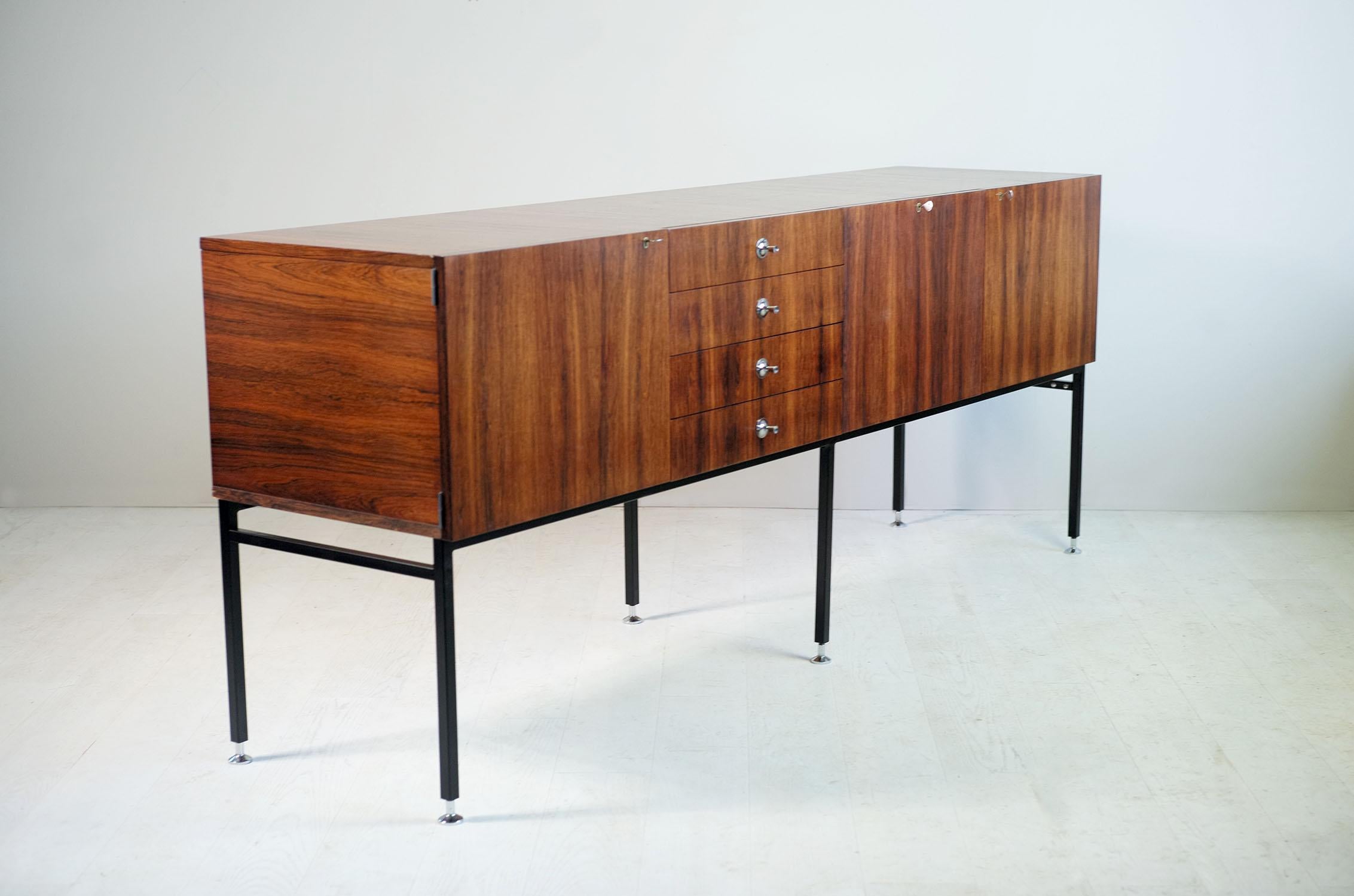 Alain Richard, Large sideboard in rosewood, chromed and black lacquered metal, 800 series edited by Meubles TV, France 1958. With a drop-down bar with its removable tray, four drawers and two doors, this sideboard rests on a base with six feet in
