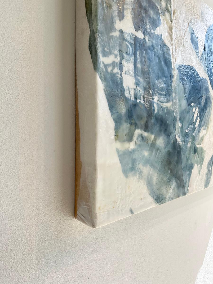 Abstract encaustic painting with dyed teal, indigo, white and beige fabrics 
