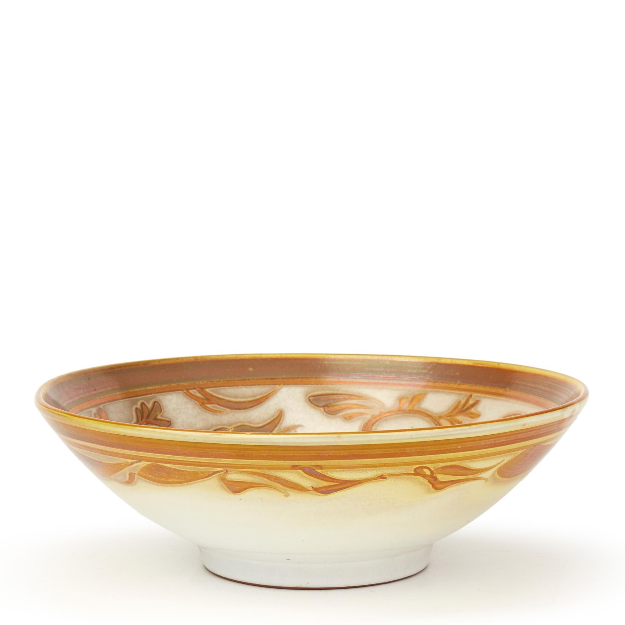 A stunning vintage Studio Pottery earthenware bowl decorated with gold and red lustre scrolling floral designs below a banded rim with a central fern stem to the centre and with similar patterns applied around the outside rim by Alan Caiger-Smith