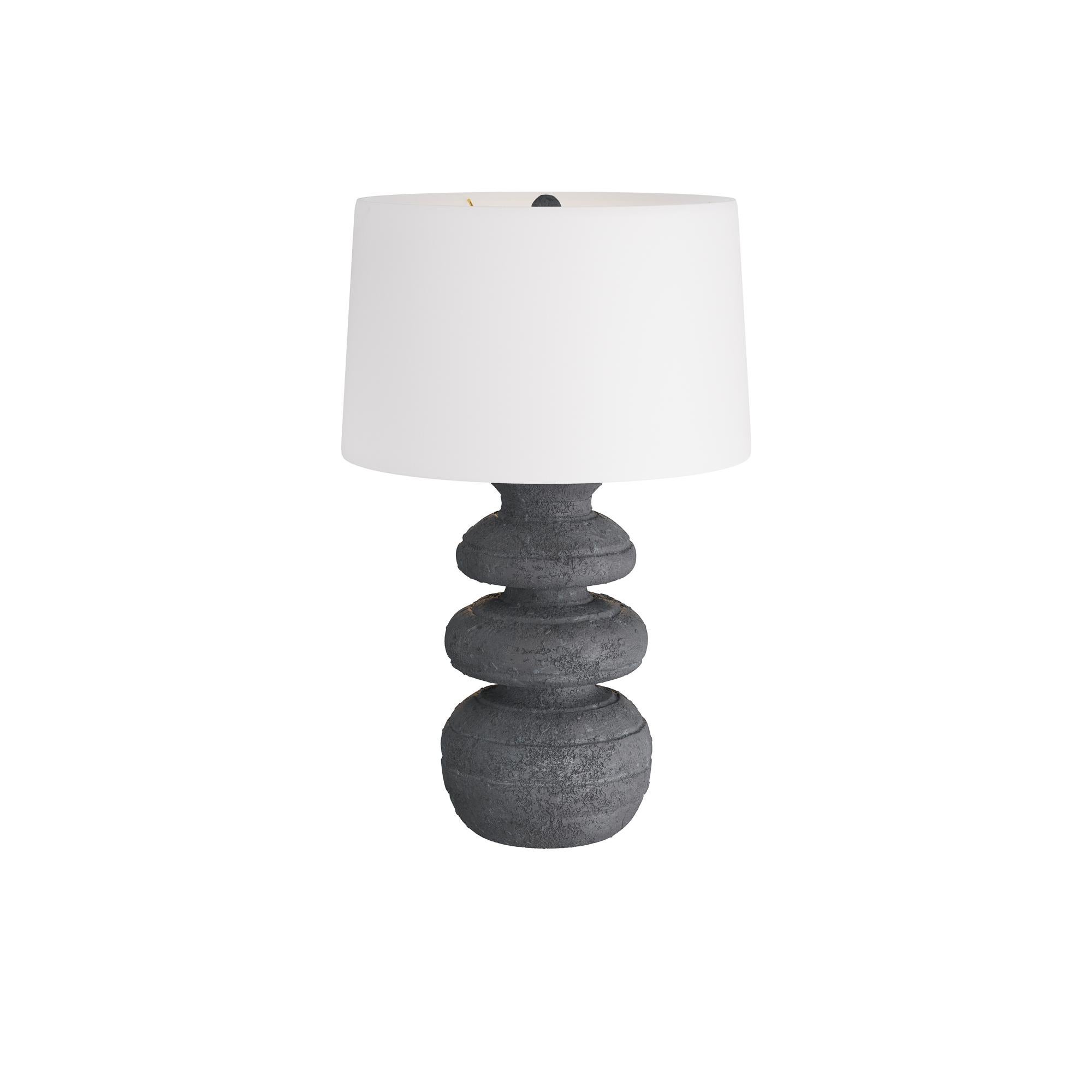 The Alanis Table Lamp is crafted of terra cotta with hand-thrown feel. Washed in a charcoal glaze, its gentle curves ripple and undulate, recalling an ancient vase. Antique brass-finished hardware and matching sphere finial complete the pleasing