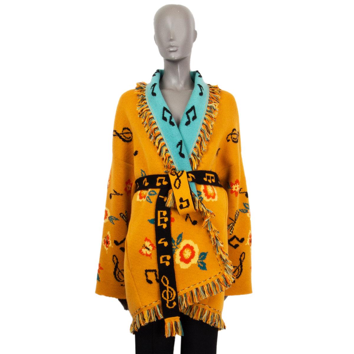 100% authentic Alanui 'Sweetheart' floral and music-note jacquard cardigan with fringe border trim in Mogul Orange cashmere (100%) with details in mustard, turquoise, black, and yellow. Fringed shawl collar, drop shoulder and two slit pockets on the
