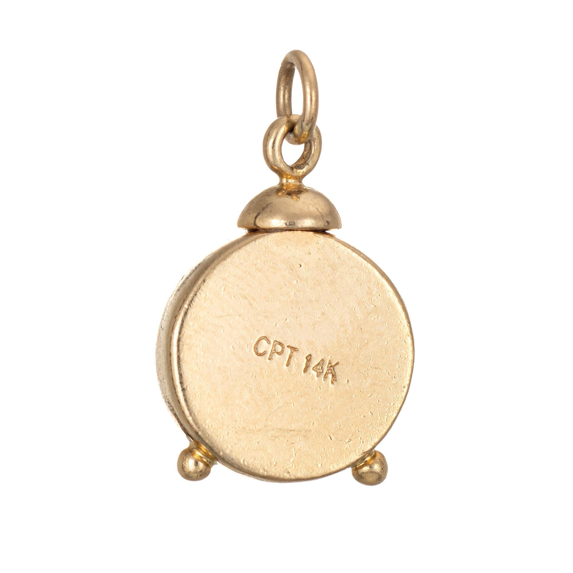 Finely detailed vintage alarm clock charm crafted in 14k yellow gold.  

The unique charm features lifelike detail of a clock dial with the numbers 