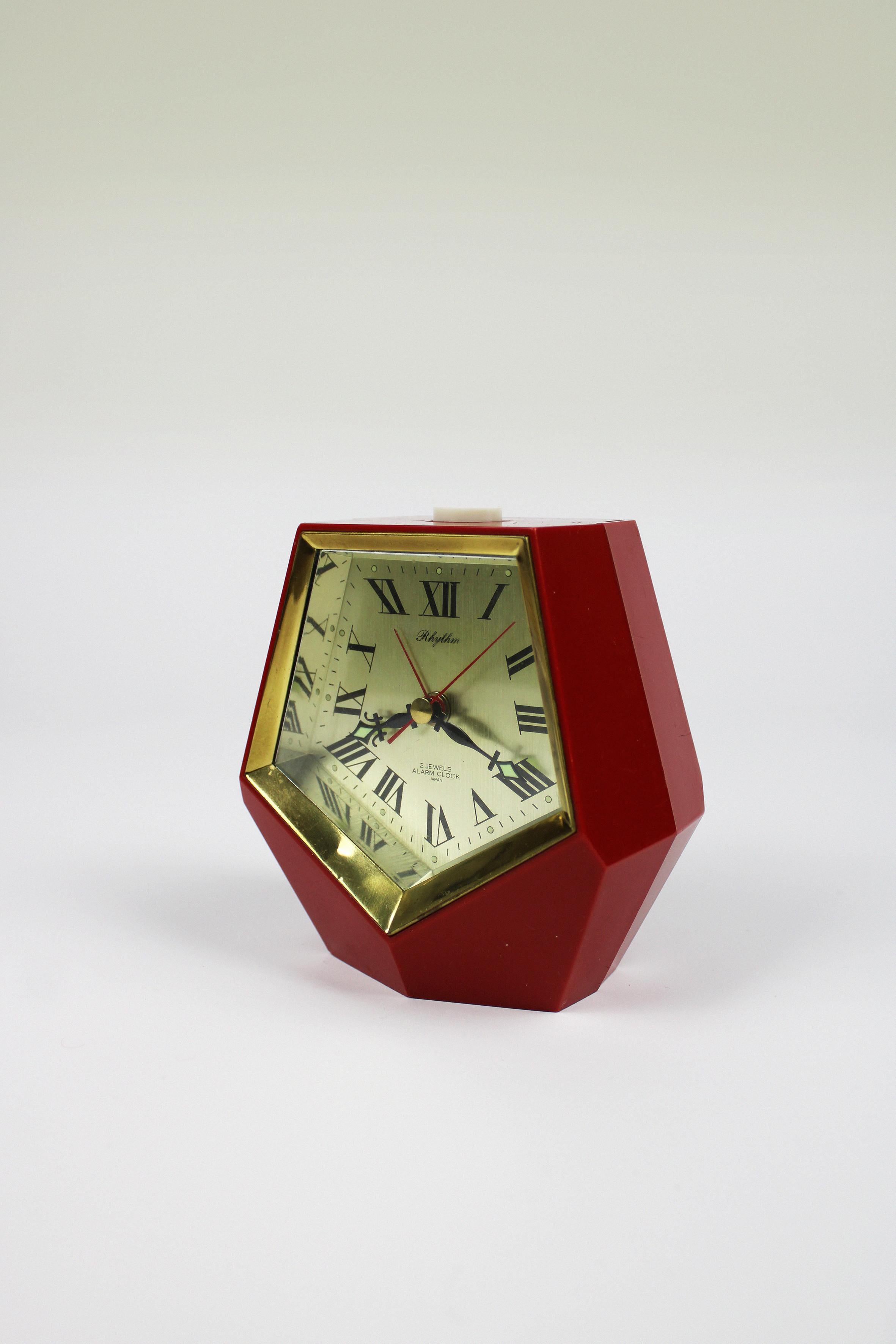 Immerse yourself in the charm of this exceptionally rare and stylish vintage alarm clock crafted by Rhythm. Its unique hexadecahedron shape and the timeless appeal of Roman numerals seamlessly integrate into any space, offering a distinctive touch