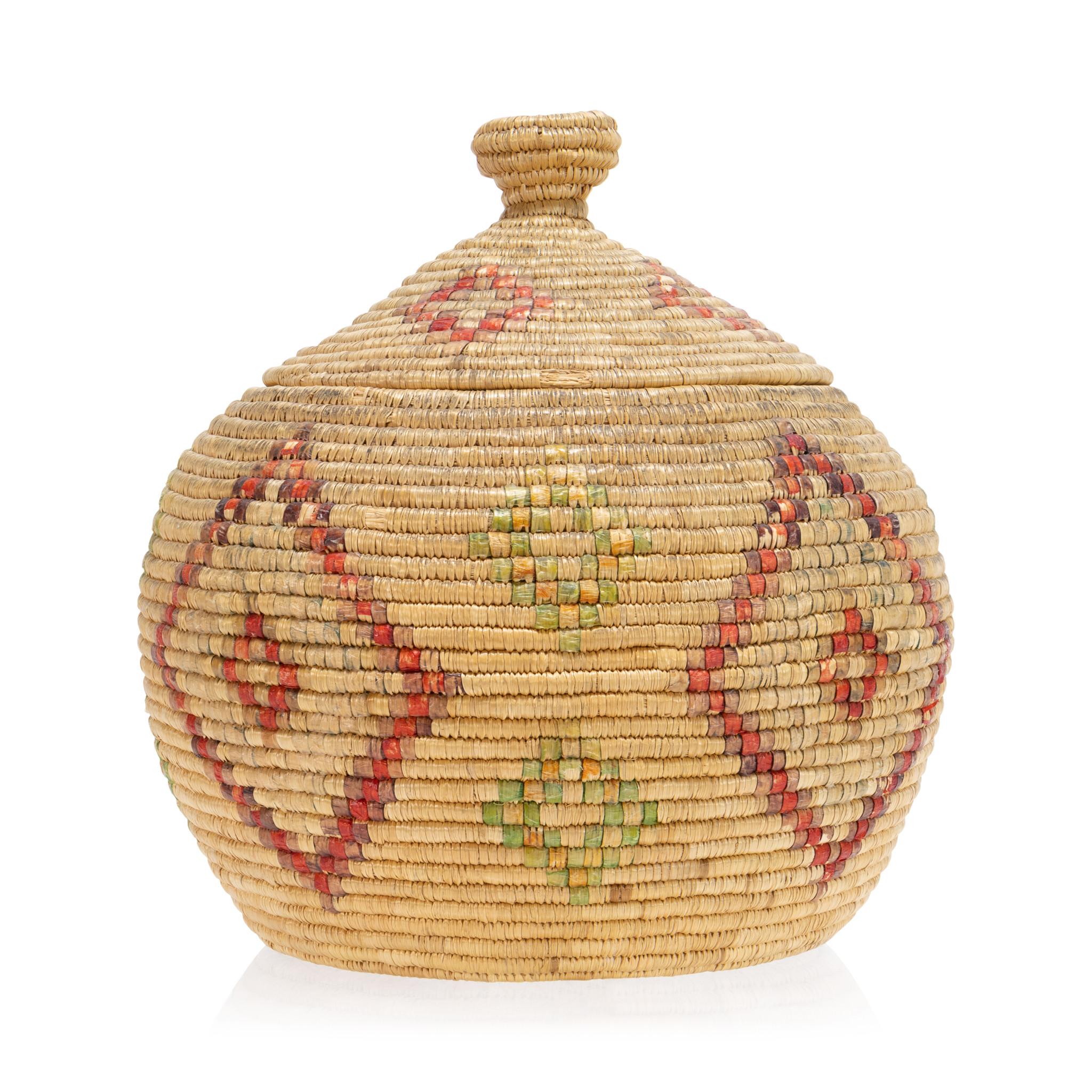Alaska Eskimo basket with lid. Red and green diamond patterns and top with knob on the lid. Nice patina, some signs of age and use. Great piece for display in a coastal cabin or handmade indigenous basketry collection. Circa 1920. Size: 9 1/2