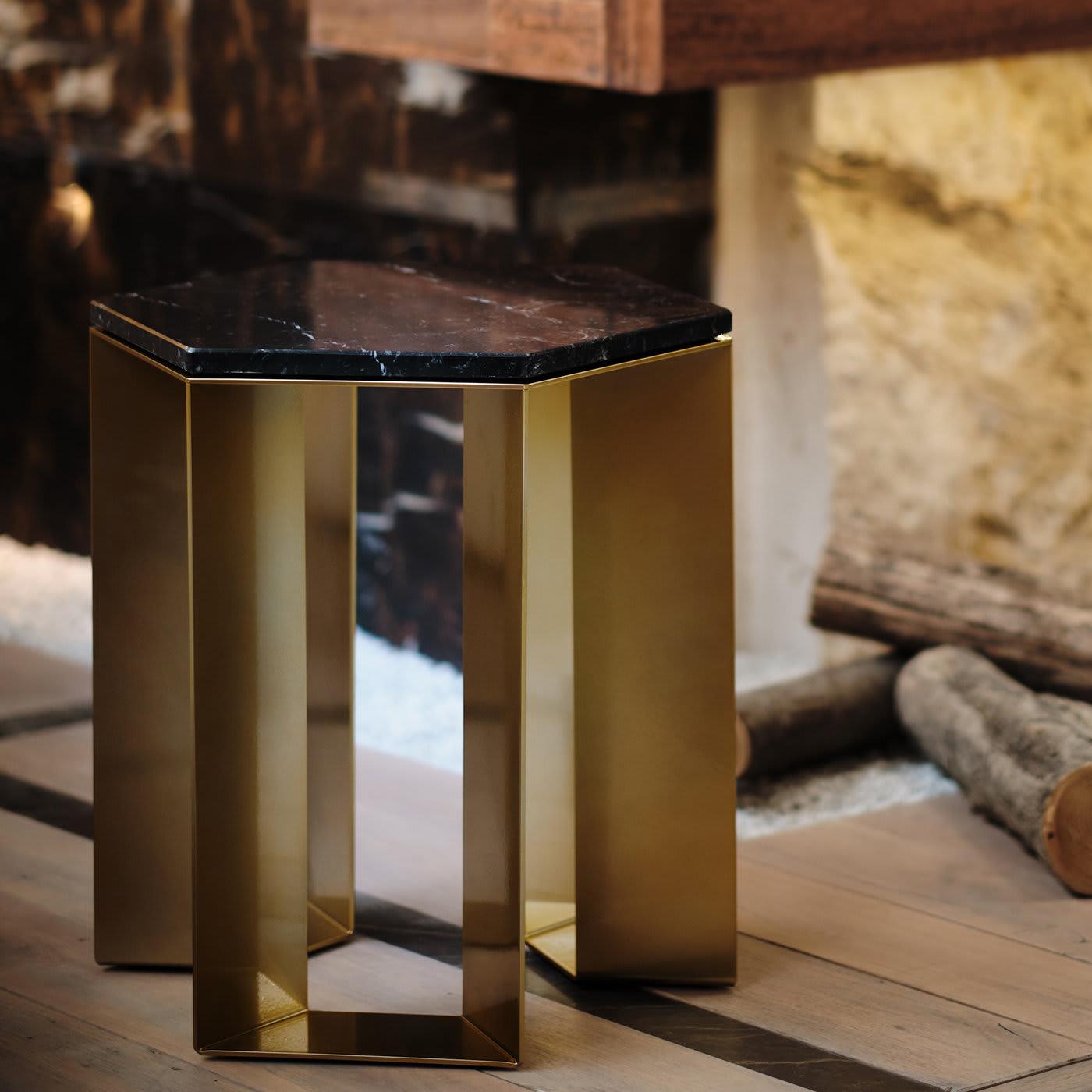 Elegante en su diseño sencillo y equilibrado, esta mesa auxiliar pertenece a una refinada serie creada por el artista Antonio Saporito para interiores contemporáneos. Limpia y esencial, presenta una base de metal lacado en tono dorado compuesta por