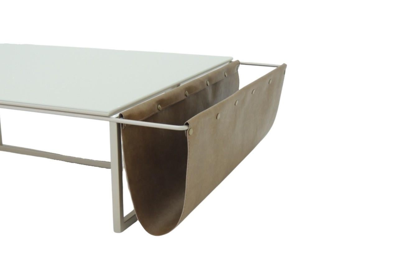 The Alba coffee table with ecological leather pocket is produced with a carbon steel structure with golden automotive paint (the finish can also be customized). The top is in MDF coated with glass, and they are also available with a variety of color