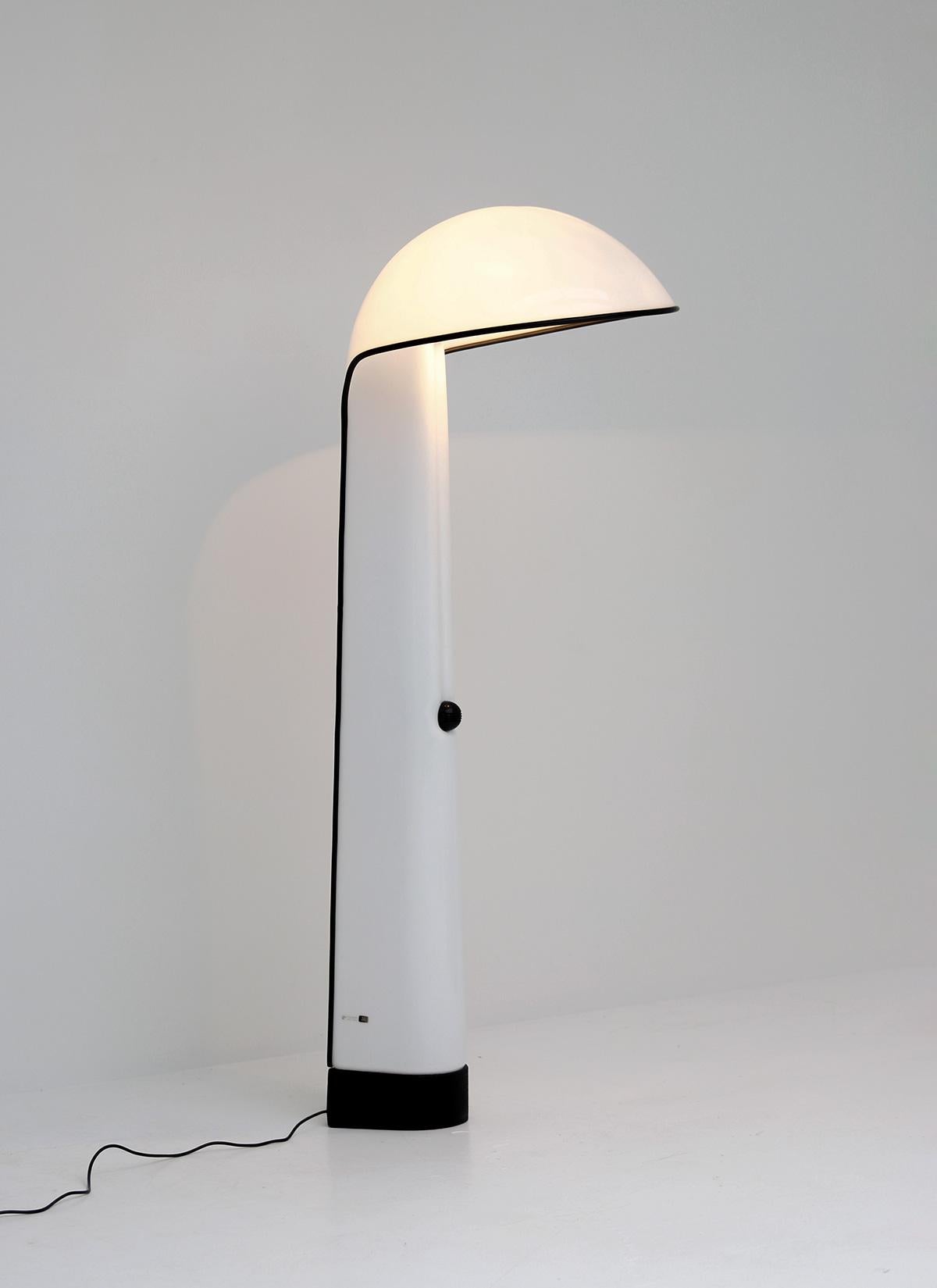 Alba floor lamp designed by Sergio Brazzoli and Ermanno Lampa in 1973 for Harvey Guzzini. It has a white plastic hood and rests on a heavy cast iron base. A round black witch is attached in the middle. This space age, sculptural lamp attests the
