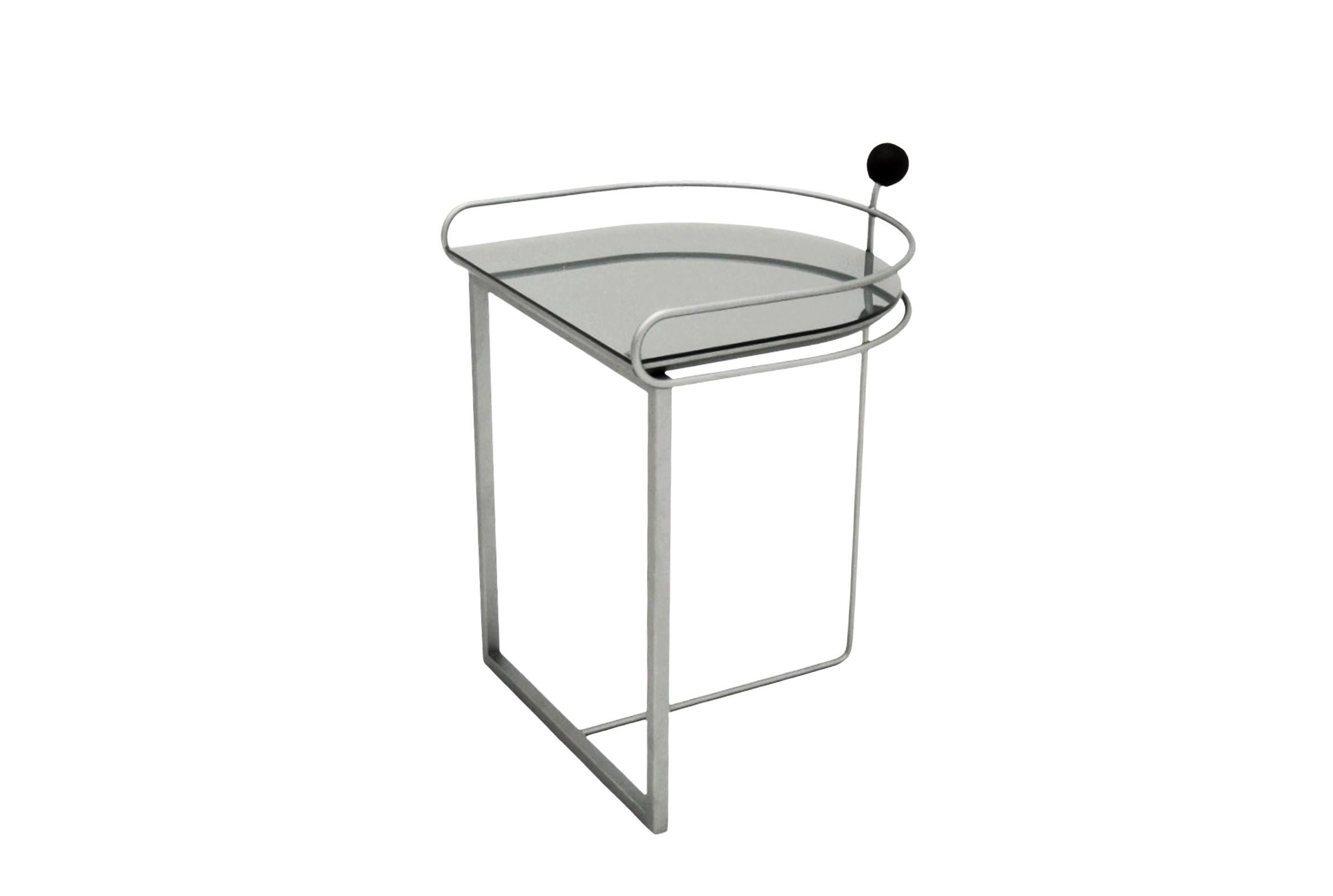 Alba Side Table is produced with a carbon steel structure with automotive painting (the finish can be customized). The top is in MDF coated with glass, and they are also available with a variety of color options. It has a decorative handle with a