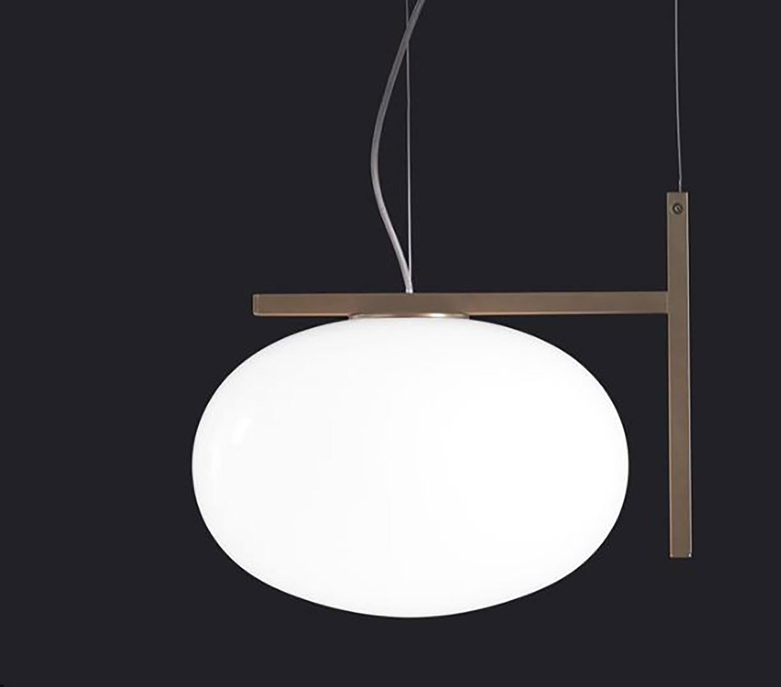 Alba suspension lamp designed by Mariana Pellegrino Soto for Oluce. The shape of the lamp resembles a drop of water, bringing the world of nature into this design. This lamp rests on a frame of satin brass that gives the lamp a modern look but also