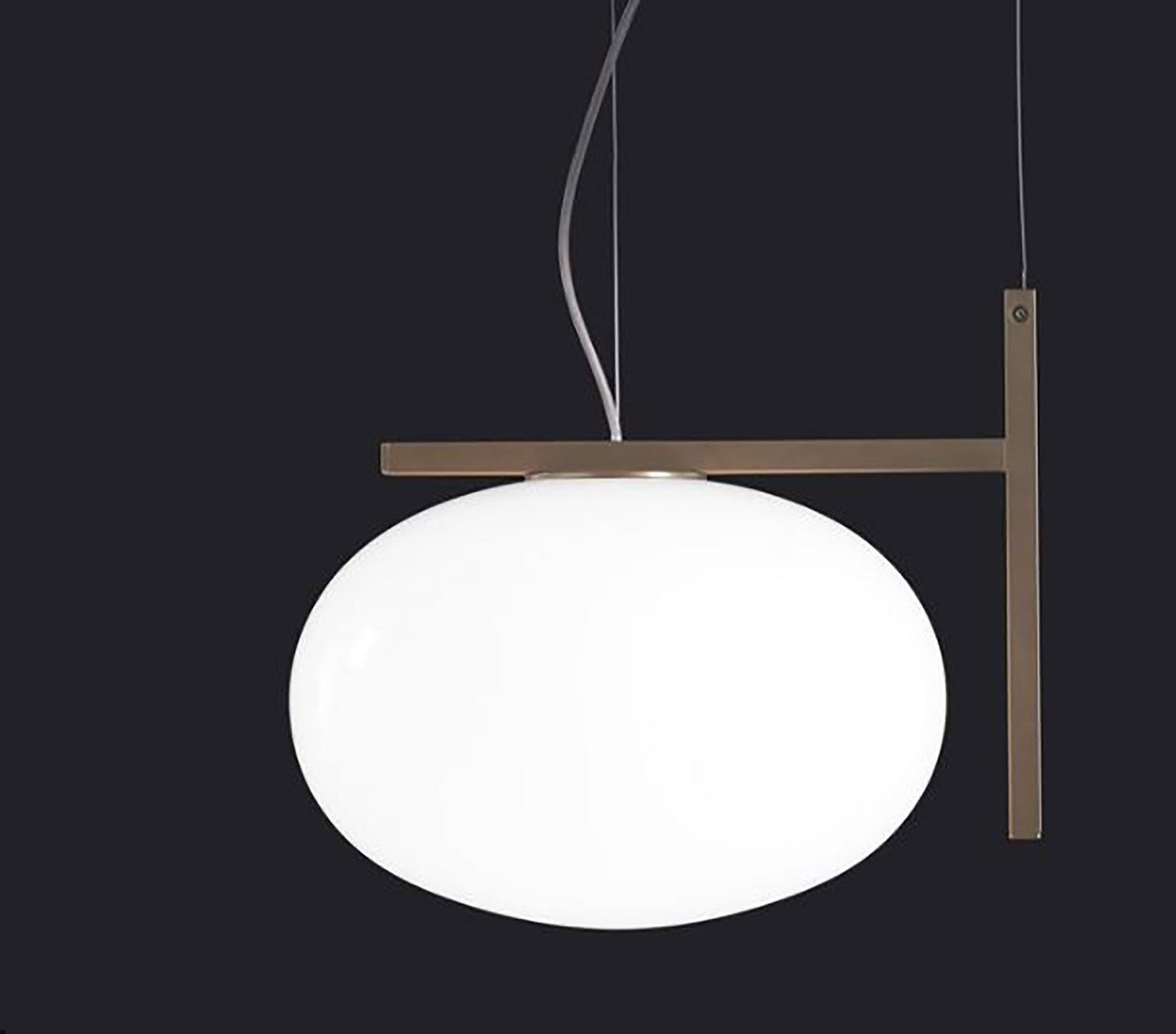Suspension Alba conçue par Mariana Pellegrino Soto pour Oluce. La forme de la lampe ressemble à une goutte d'eau, apportant le monde de la nature dans ce design. Cette lampe repose sur un cadre en laiton satiné qui lui donne un aspect moderne mais