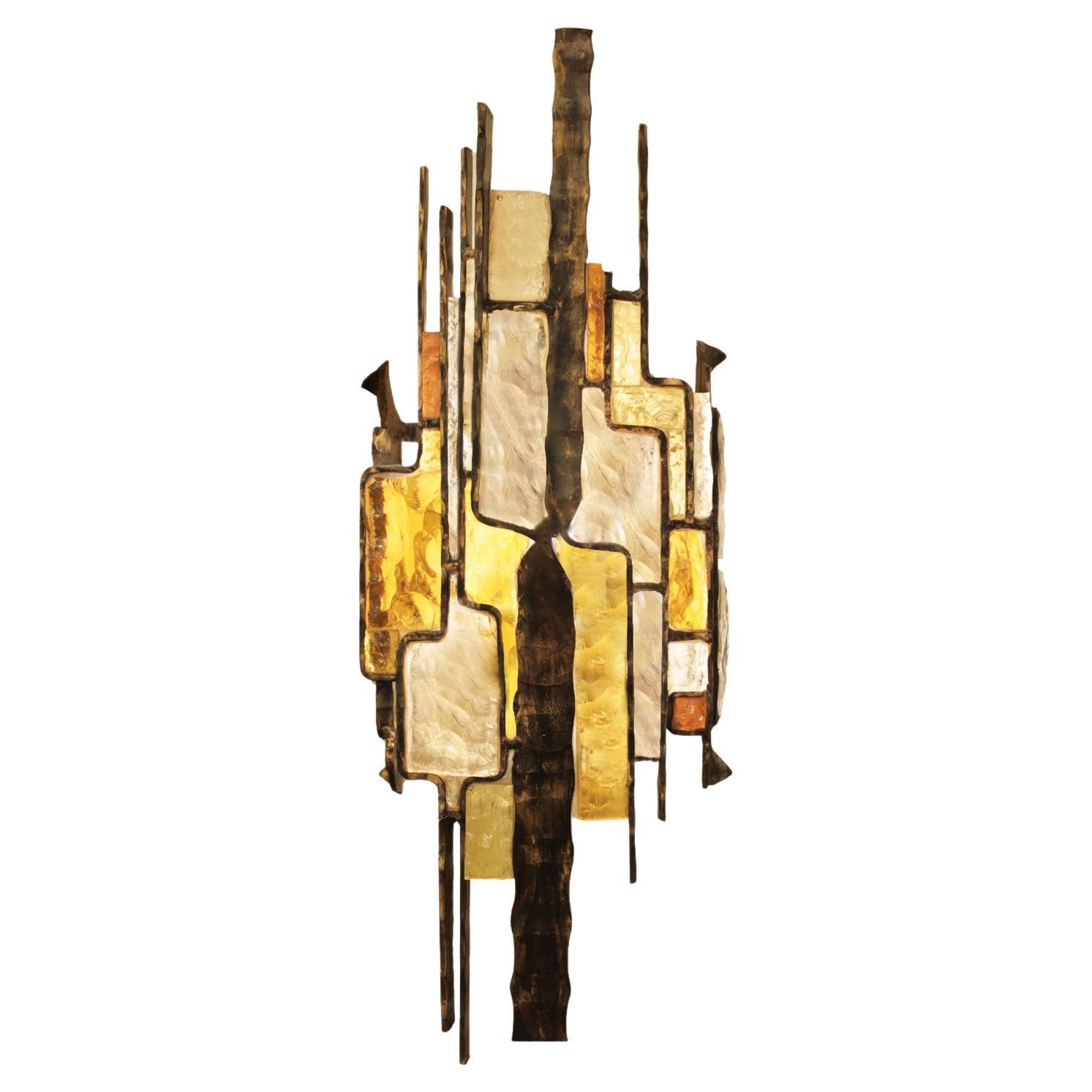 Brutalist style Murano glass and iron sconce with inset, irregular shaped amber, smoke and clear art glass arranged in an abstract pattern. Designed by Alberto Poli for Poliarte. Italy, 1960's. 

There are 7 sconces available. Priced Individually.