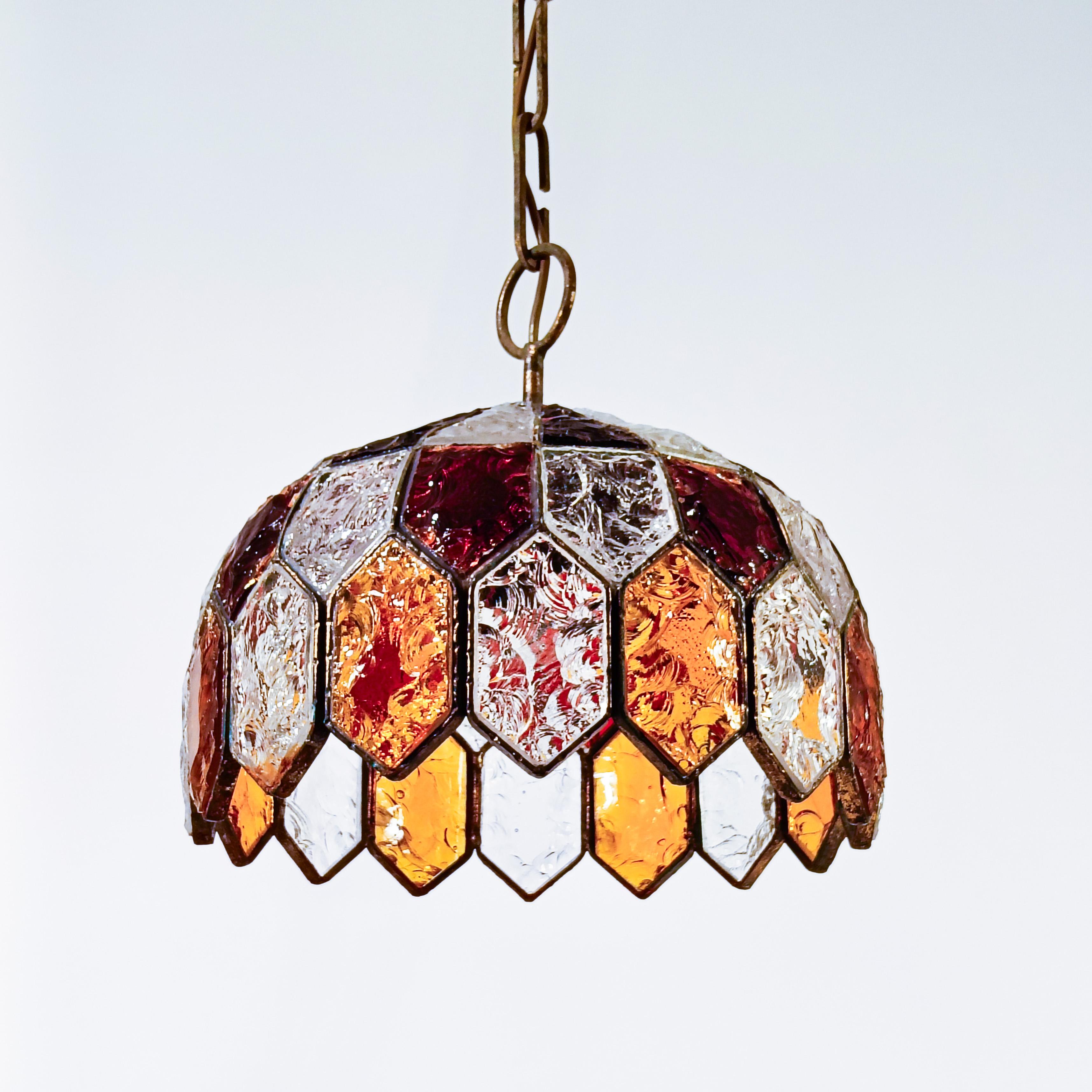 Lampada a sospensione brutalista di Albano Poli per Longobard, Italia, anni '70. Struttura in ferro battuto e saldato, con finitura oro consumato, e cristalli multicolori martellati a forma di nido d'ape. Chiaramente in stile brutalista. Realizzato