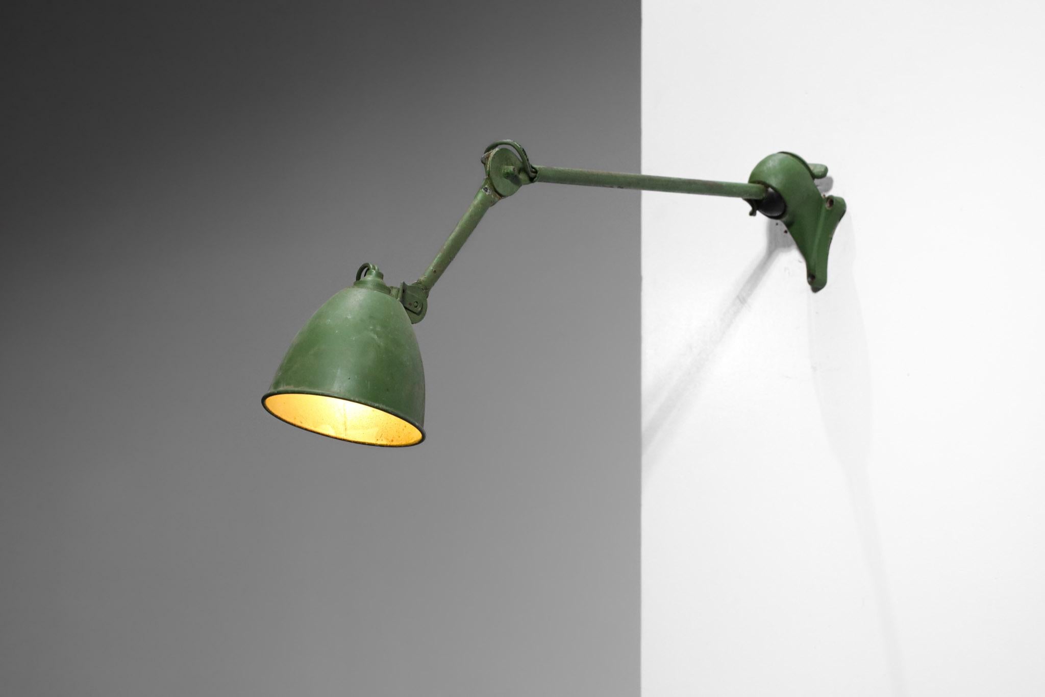 Lampe d'atelier française créée par Albert Albin Gras dans les années 50. Structure, abat-jour et bras articulés en métal, le tout en vert (peinture d'origine). Très belle patine d'usage sur l'ensemble de la lampe (voir photos). Modèle de lampe très