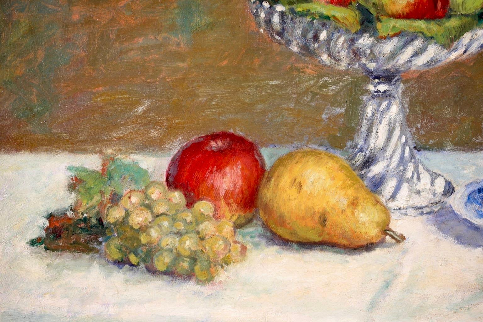 A beautiful still life oil on canvas circa 1895 by French post impressionist painter Albert André. The piece depicts a glass bowl filled with red & green apples and a pear, with further apple and pear and green grapes below. There is a blue and