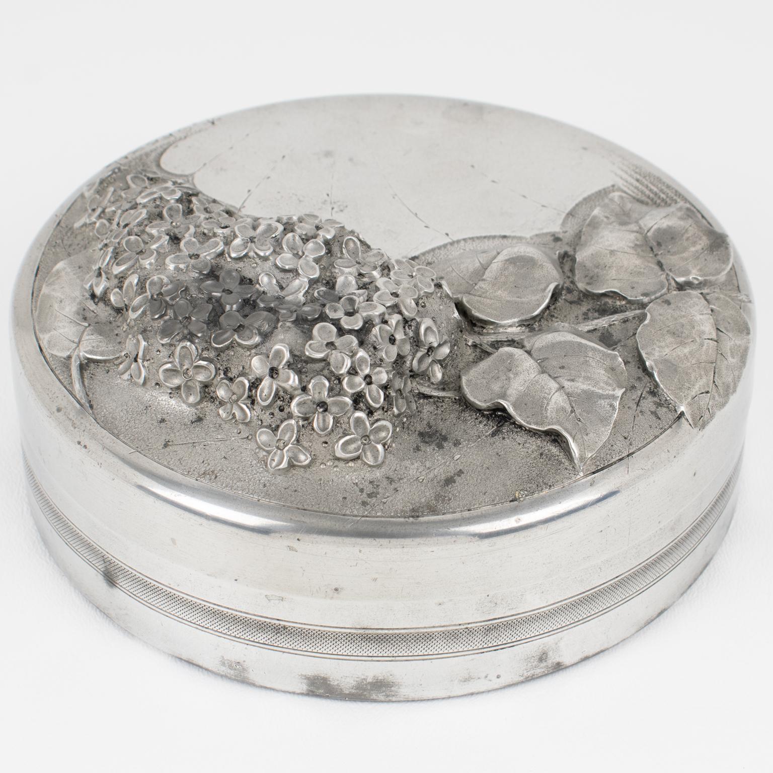 Albert Chezal designed this stunning Art Nouveau distinctively illustrated dinanderie-pewter covered box, handcrafted in France's Etains d'Art workshop around 1910. The large hand-wrought round shape has a typical Art Nouveau floral embossed design