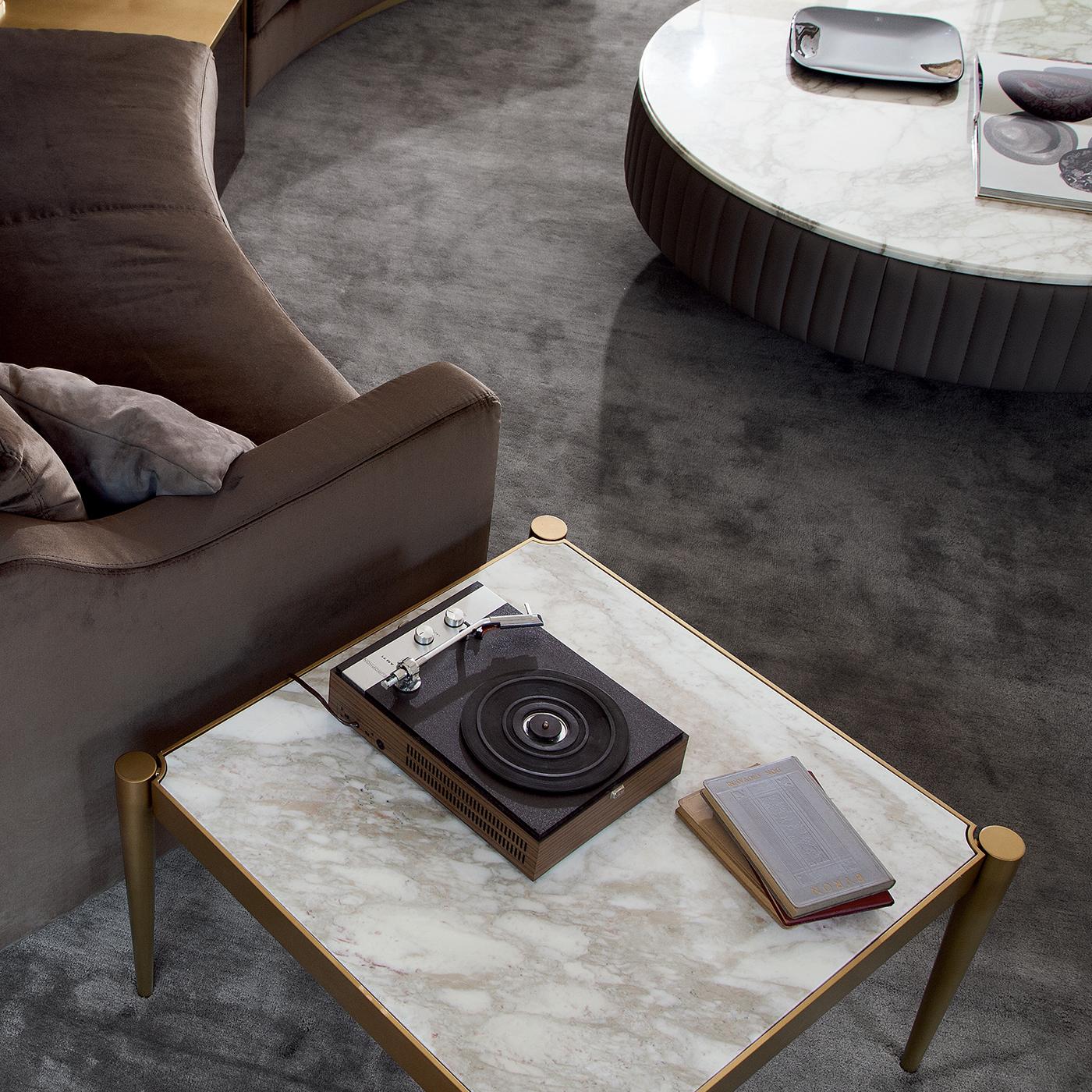 The clean-cut lines of this polished coffee table contrast with the opulence of the Calacatta gold marble top and give it a versatile quality that makes it suitable for all decors. The square stainless steel structure features a unique encased