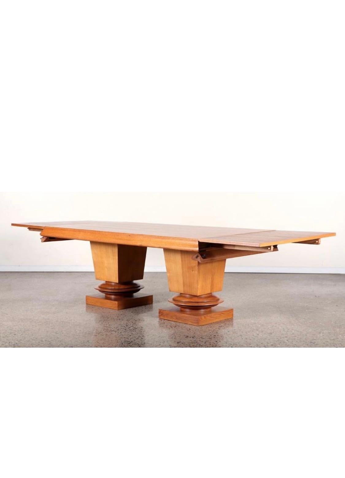 An outstanding French Oak Double Pedestal Dining Table. A double pedestal oak extension dining table by Albert Guenot, c. 1940. Substantial, sculptural pedestal legs 
Extension leaves pull out from either end of table by pulling edge down and