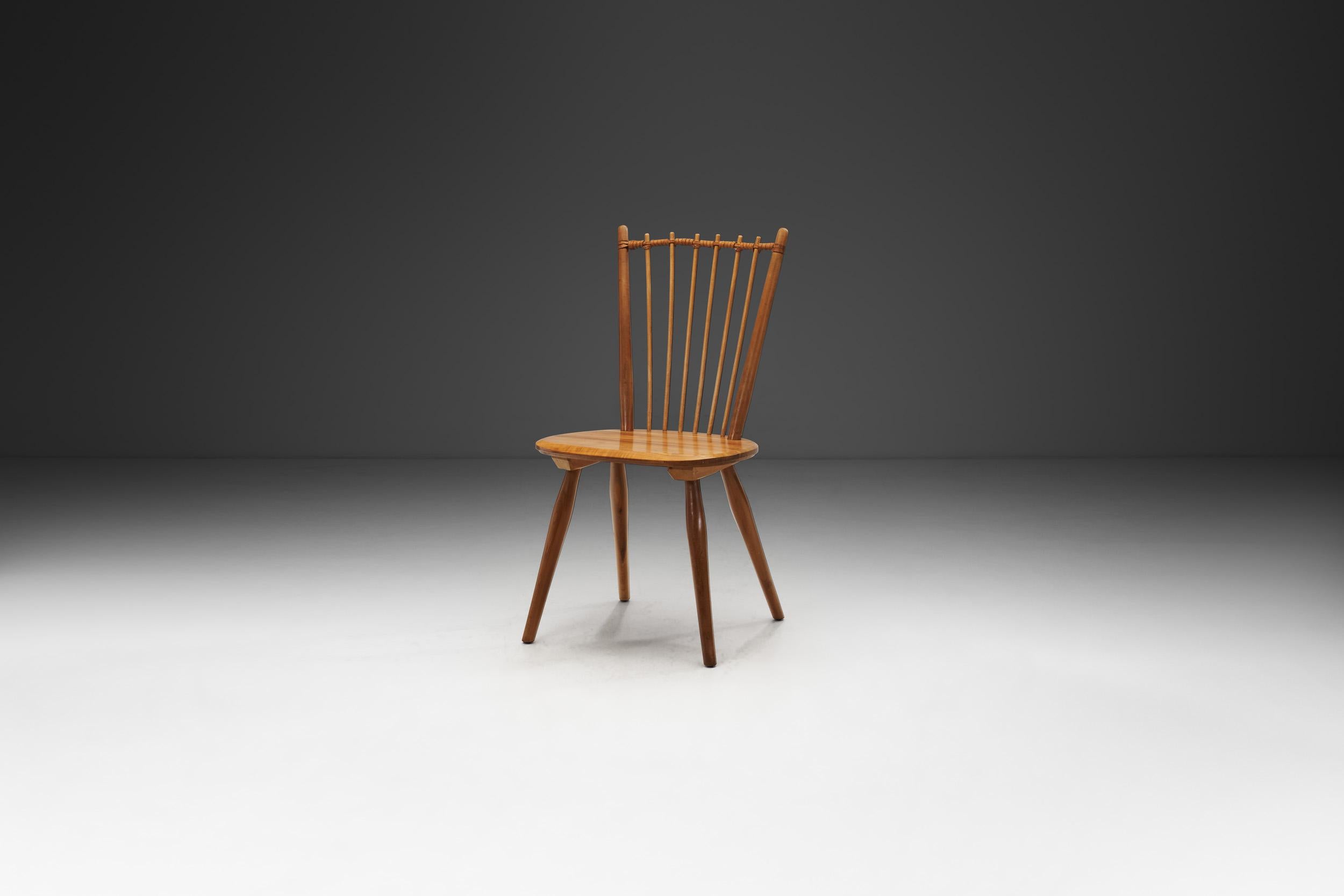 Cette chaise Arts and Crafts est peut-être le modèle le plus connu du designer allemand Albert Haberer. Le dossier flexible composé de fines broches, maintenu par la connexion en cuir tressé, fait de ce modèle une pièce immédiatement reconnaissable