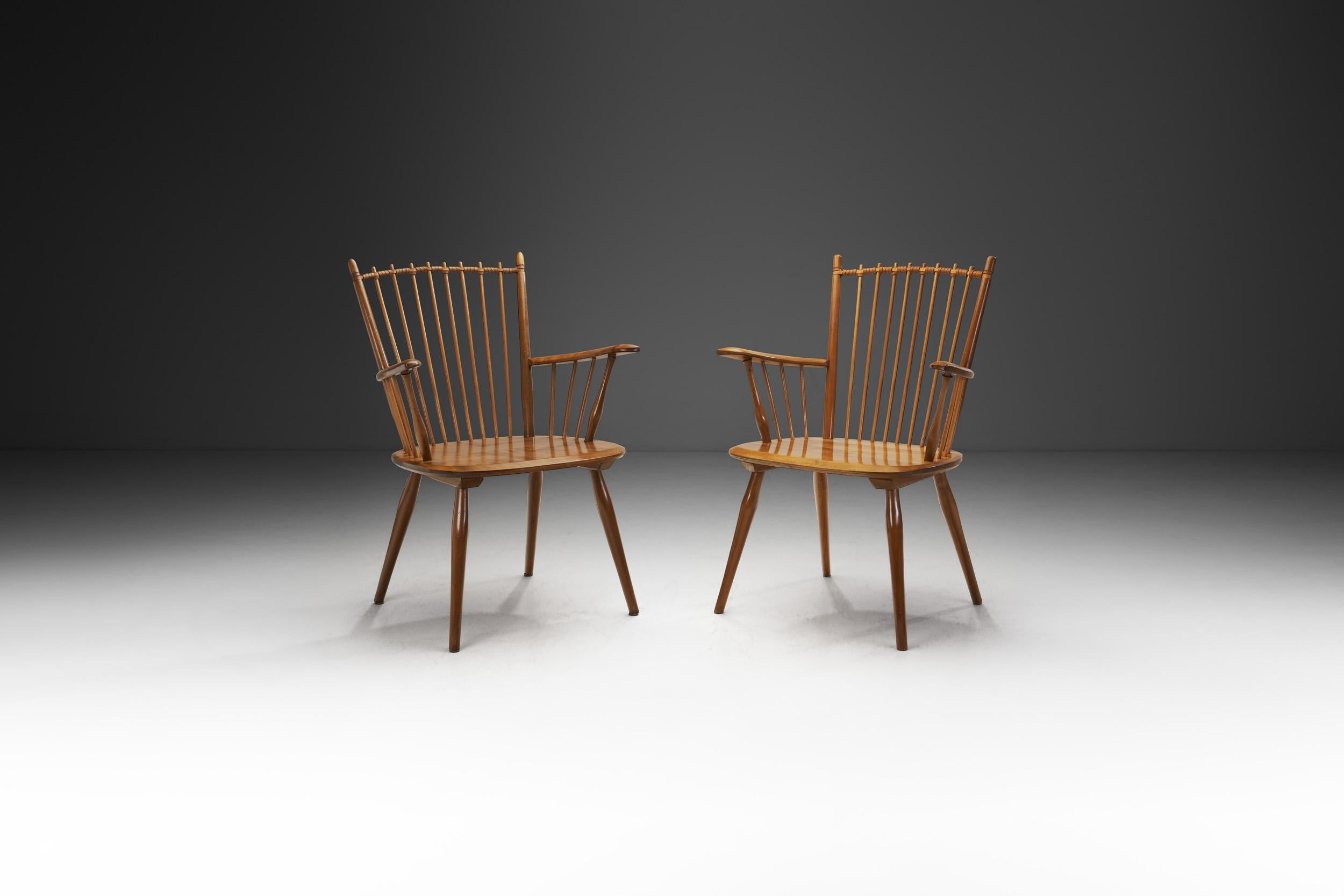 Cette paire de chaises Arts and Crafts est une version du modèle peut-être le plus connu du designer allemand Albert Haberer. Les dossiers et les accoudoirs en fuseau font de ce modèle une pièce immédiatement reconnaissable de l'histoire du design