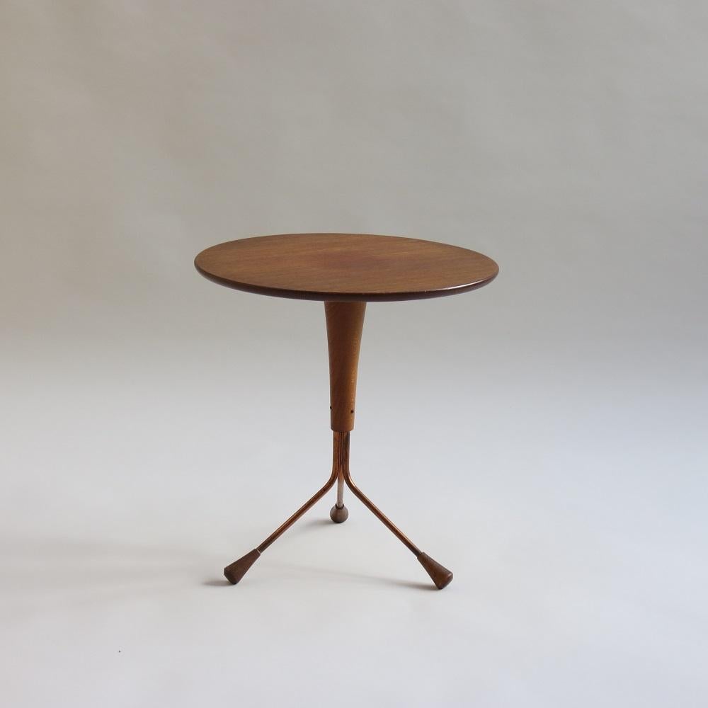 Wonderful small Teak tripod table by Albert Larsson. 

Teak top with Brass tubular legs with turned Teak details to the foot. 

Retains the original sticker to the underside.

Good over all condition, some shading to the centre of the Teak top in