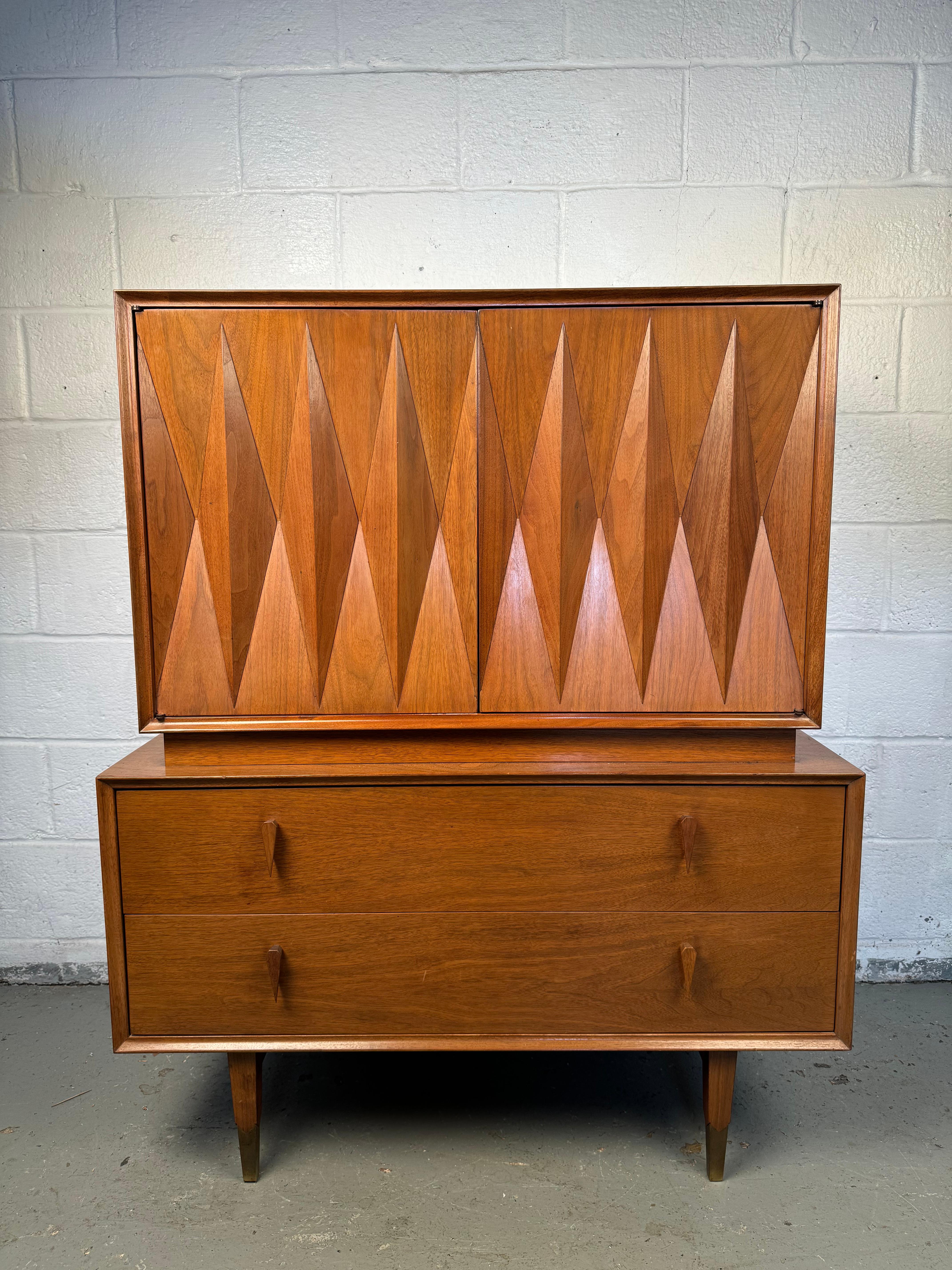 Embrace the elegance of mid-century modern design with the American of Martinsville Diamond Front Highboy Dresser, a true masterpiece designed by the legendary Albert Parvin. This stunning dresser effortlessly blends artistry with functionality,