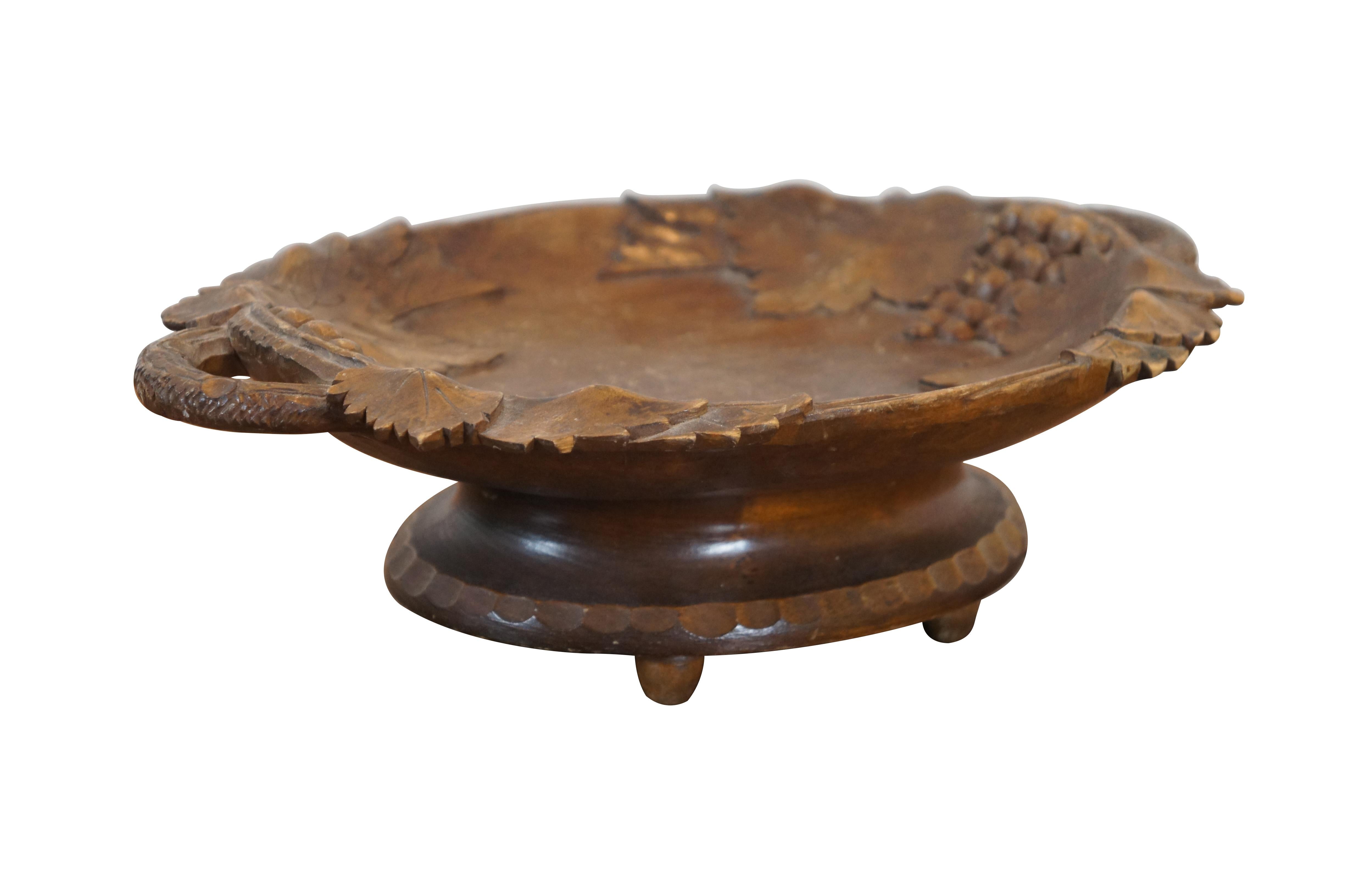 Vintage Albert Schild Interlaken carved wood footed bowl / compote / bon bon dish. Carved in a folk art / Black Forest style with grape vine, fruit and leaves with branch shaped handles. Supported on four bun feet. Plays Happy Birthday and Tea for