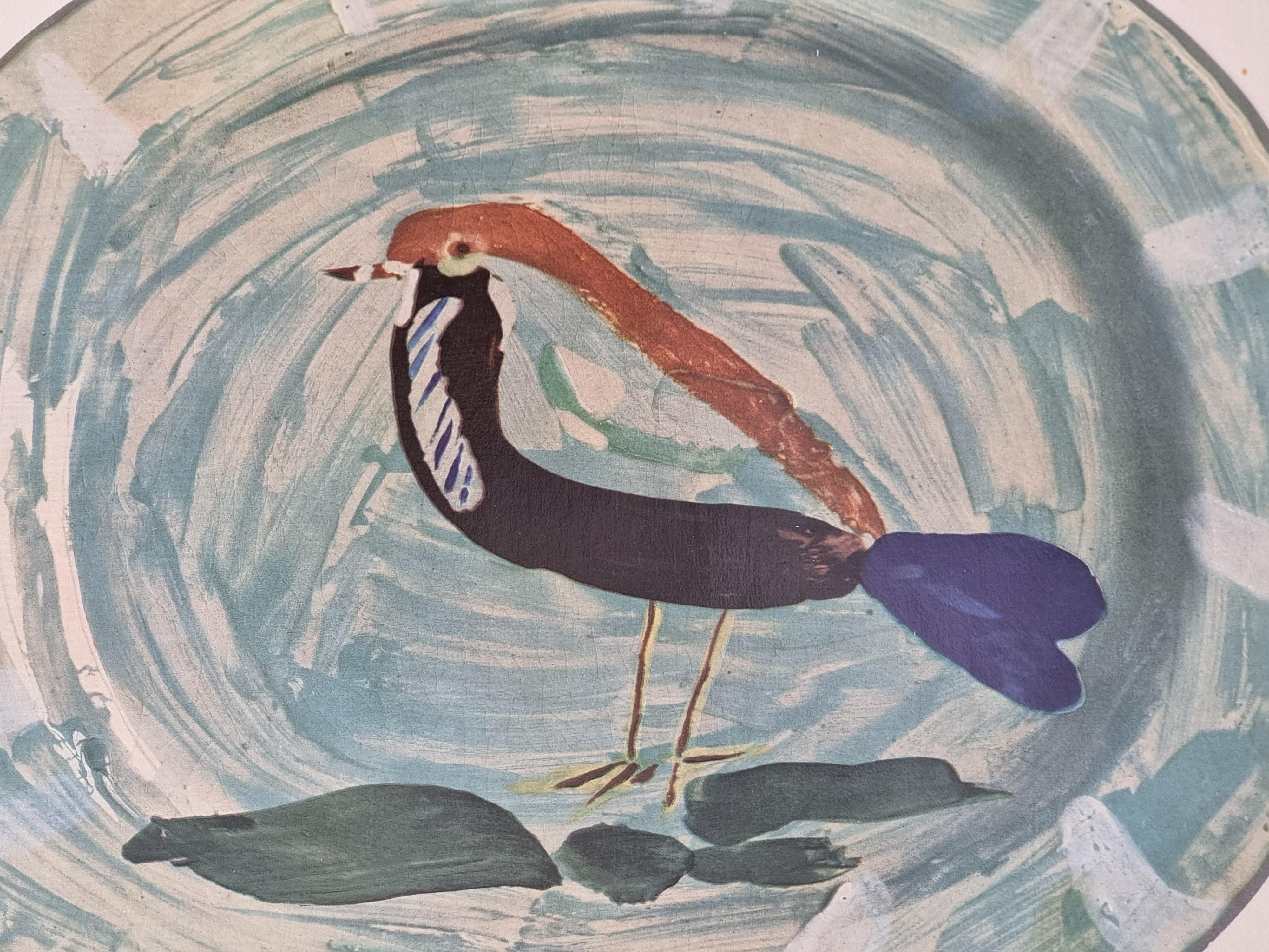 Eine exquisite glänzende polychrome Druck von Picasso Vallauris Keramik Platte, die einen Vogel in blau. Der Farbdruck ist auf einem dicken, hochwertigen Papier mit Zierlinien angebracht. 

Der Druck stammt aus einer limitierten Auflage des