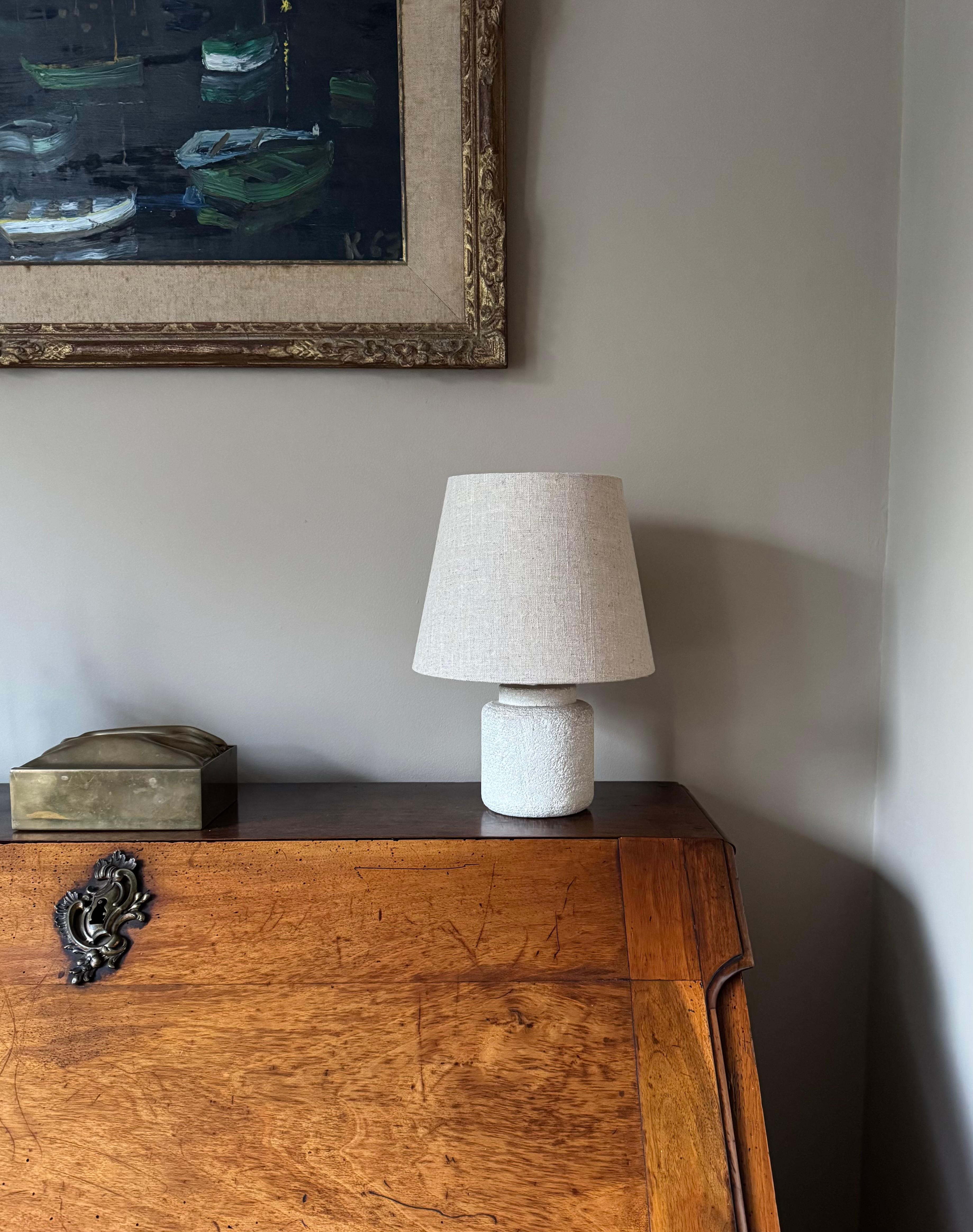 A French small carved stone lamp in the style of Albert Tormos. Rewired and sold with small linen shade.