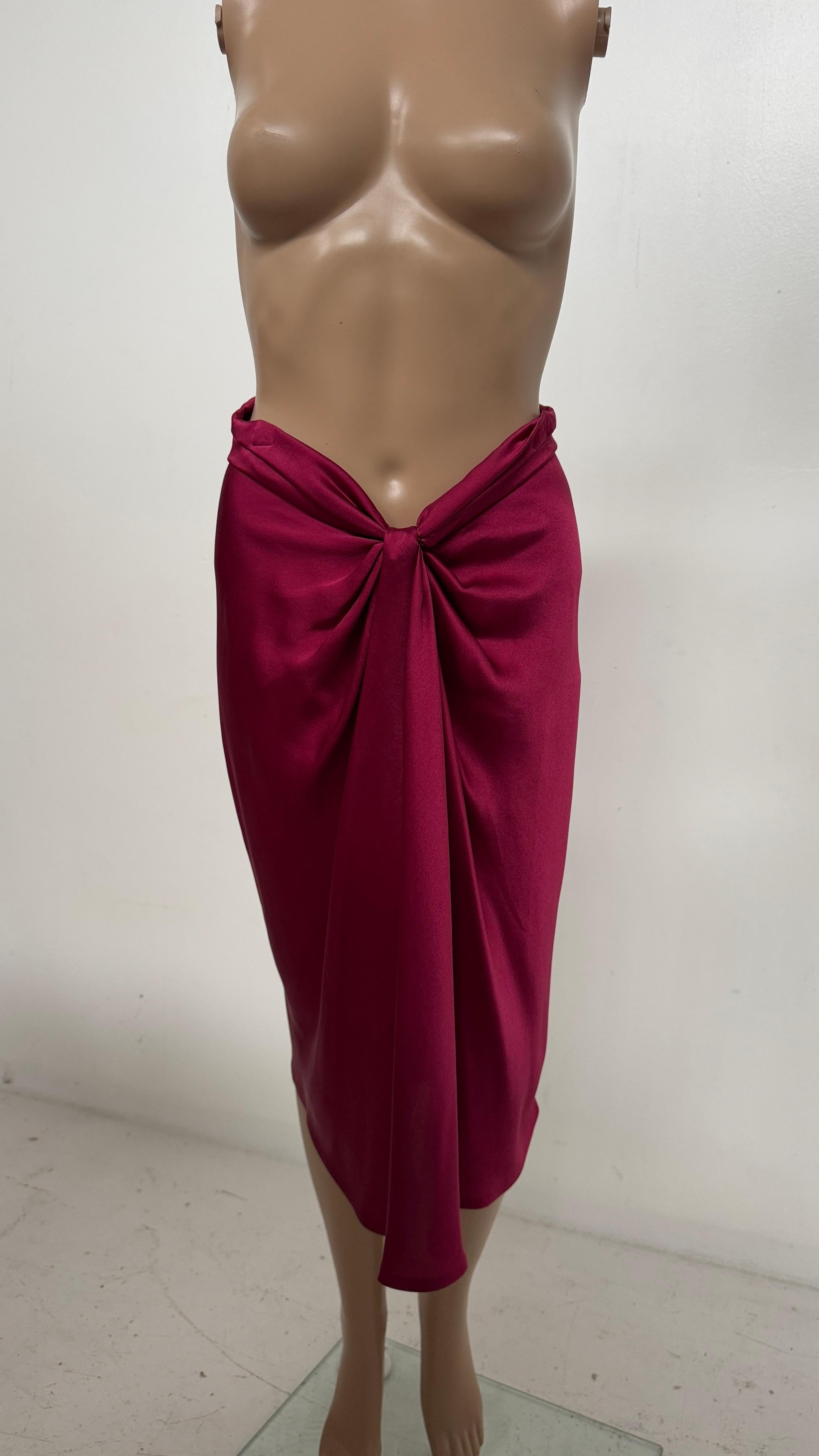 Elevate your wardrobe with this exquisite silk skirt by Alberta Ferretti, a true embodiment of Italian craftsmanship and timeless femininity. Crafted in a rich, deep fuchsia hue, the skirt features a luxurious draped front knot that adds fluid