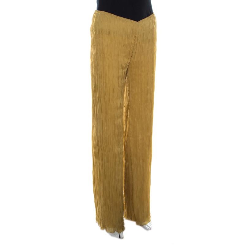 These palazzo trousers from Alberta Ferretti deserve a special place in your wardrobe. In a lovely shade of mustard, these trousers are made of silk and rayon and feature a crinkled silhouette. They can be paired well with a crisp shirt as well as a