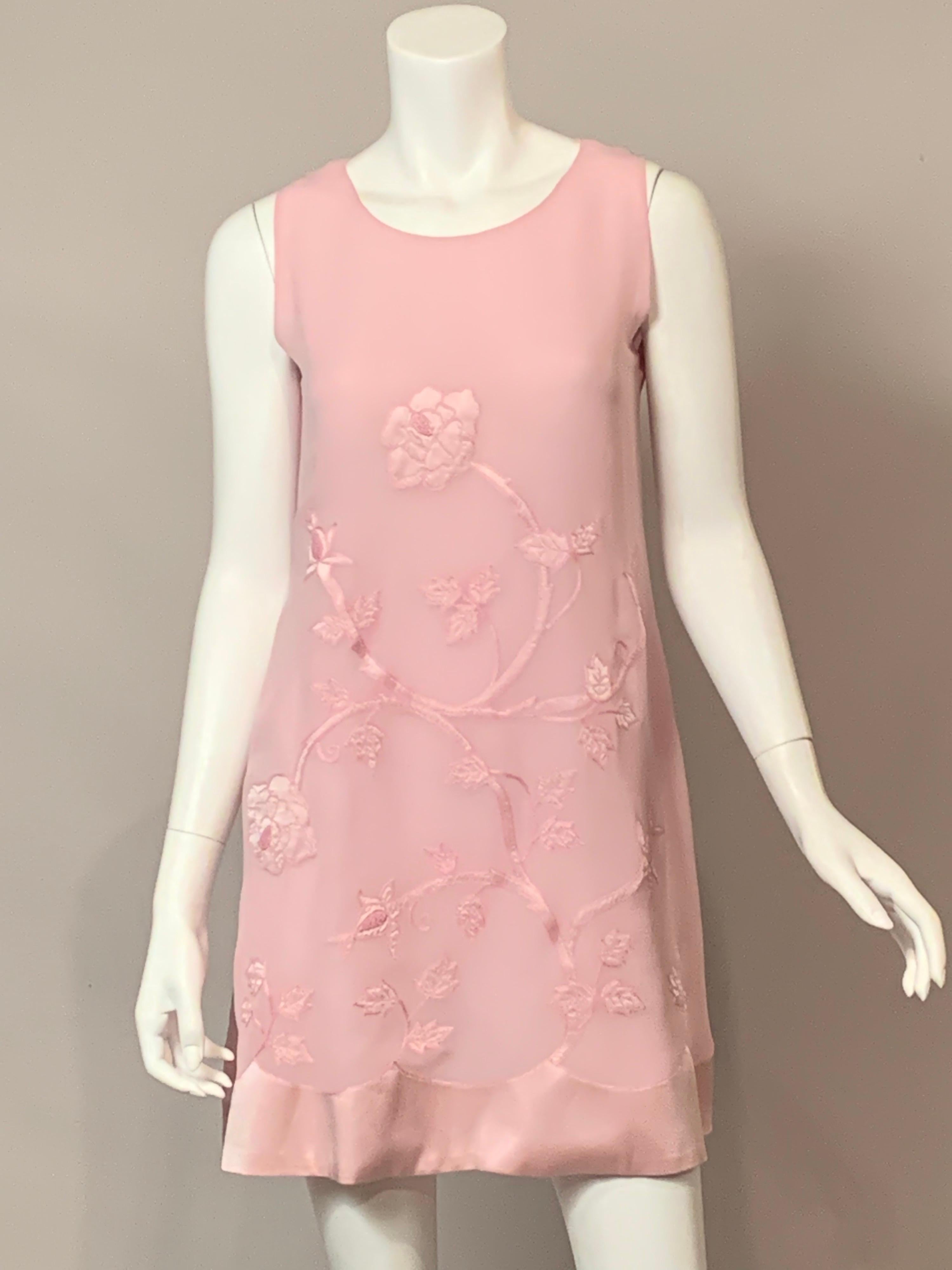 This is a very feminine dress from Italian designer Alberta Ferretti.  The dress is sleeveless with an A line shape.  There is a wide scalloped satin band at the hemline with a flower and vine satin applique branching out from this band.  The vine