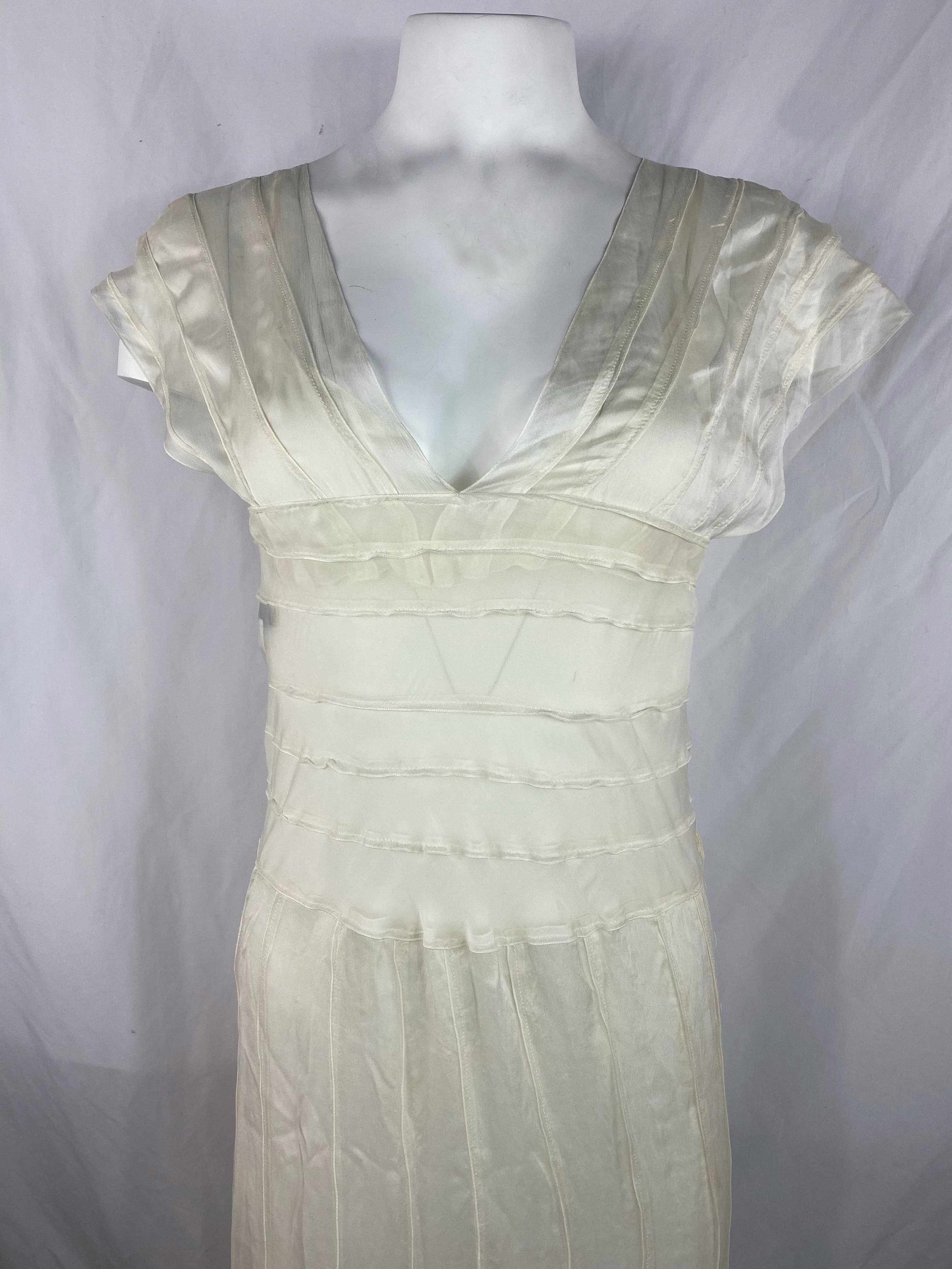 Product details:

The dress is made out of 100% silk, featuring white, cream color with ruffled design detail, v- neck line, short sleeves, floor length and side button closure.