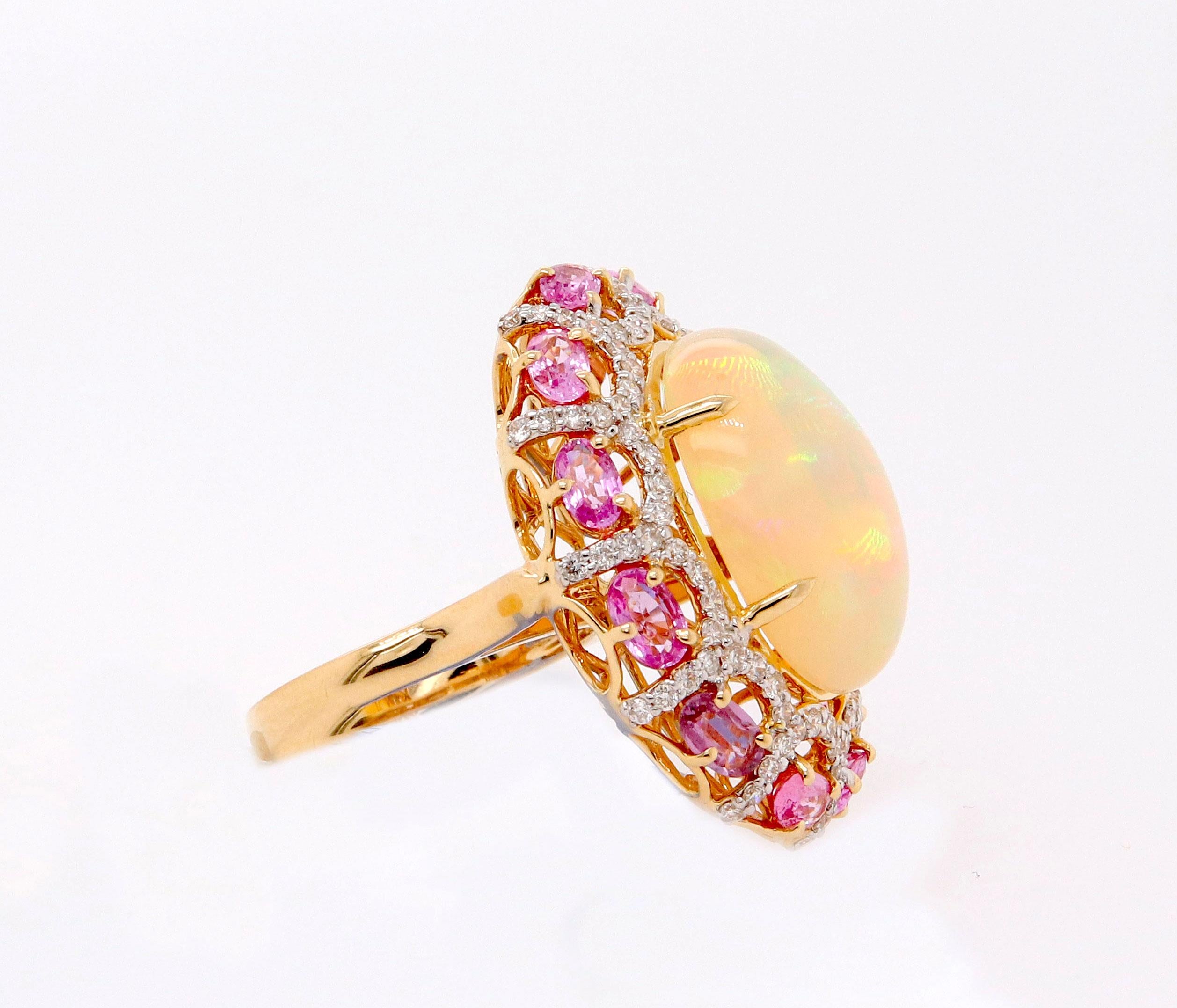Material: 14k Yellow Gold 
Center Stone Detail:  1 Oval Opal at 8.85 Carats - Measuring 19 x 15 mm
Mounting Stone Details:  12 Round Pink Sapphires at 4.20 Carats
Diamond Details: 96 Brilliant Round White Diamonds at 0.93 Carats - Clarity: SI /