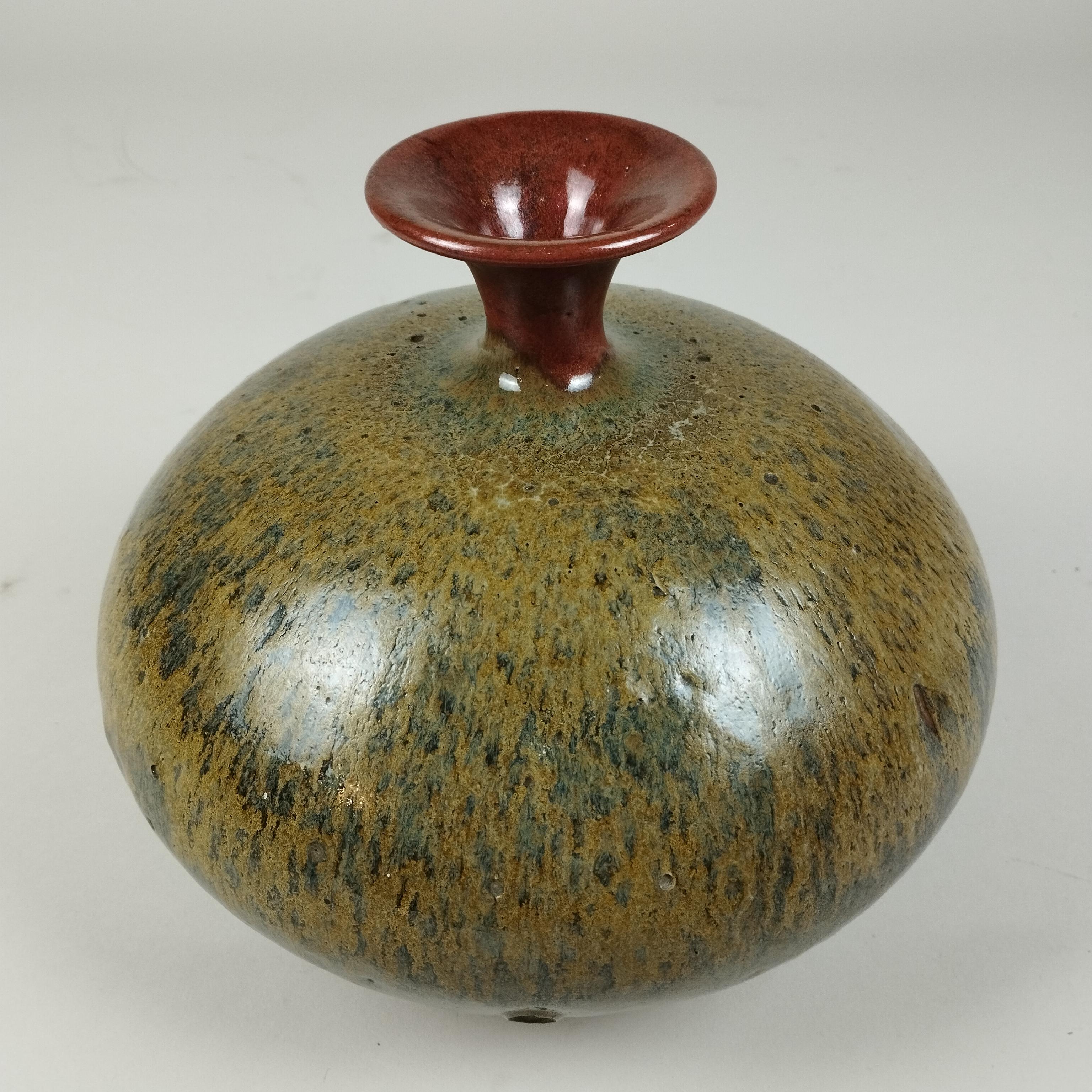 A Mexican high temperature vase by Alberto Díaz de Cossío. Manufactured at the Taller Experimental de Cerámica in Mexico City (Experimental Ceramic's Workshop). The bulged vase with narrow neck in orange shows green and ochre colors. A one of a kind