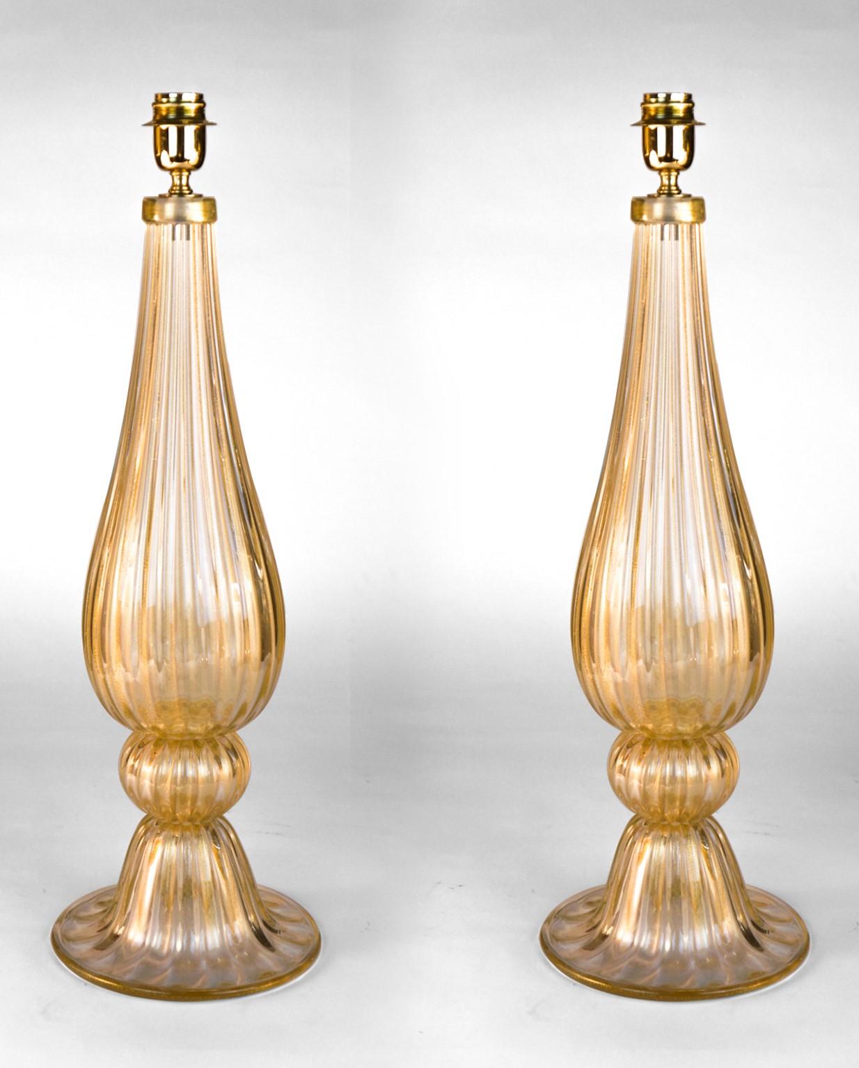 Exclusive pair of Murano glass table lamps in crystal color in gold leaf 24 carats. 
By touching the lamps, you can hear the various grooves made especially by the 