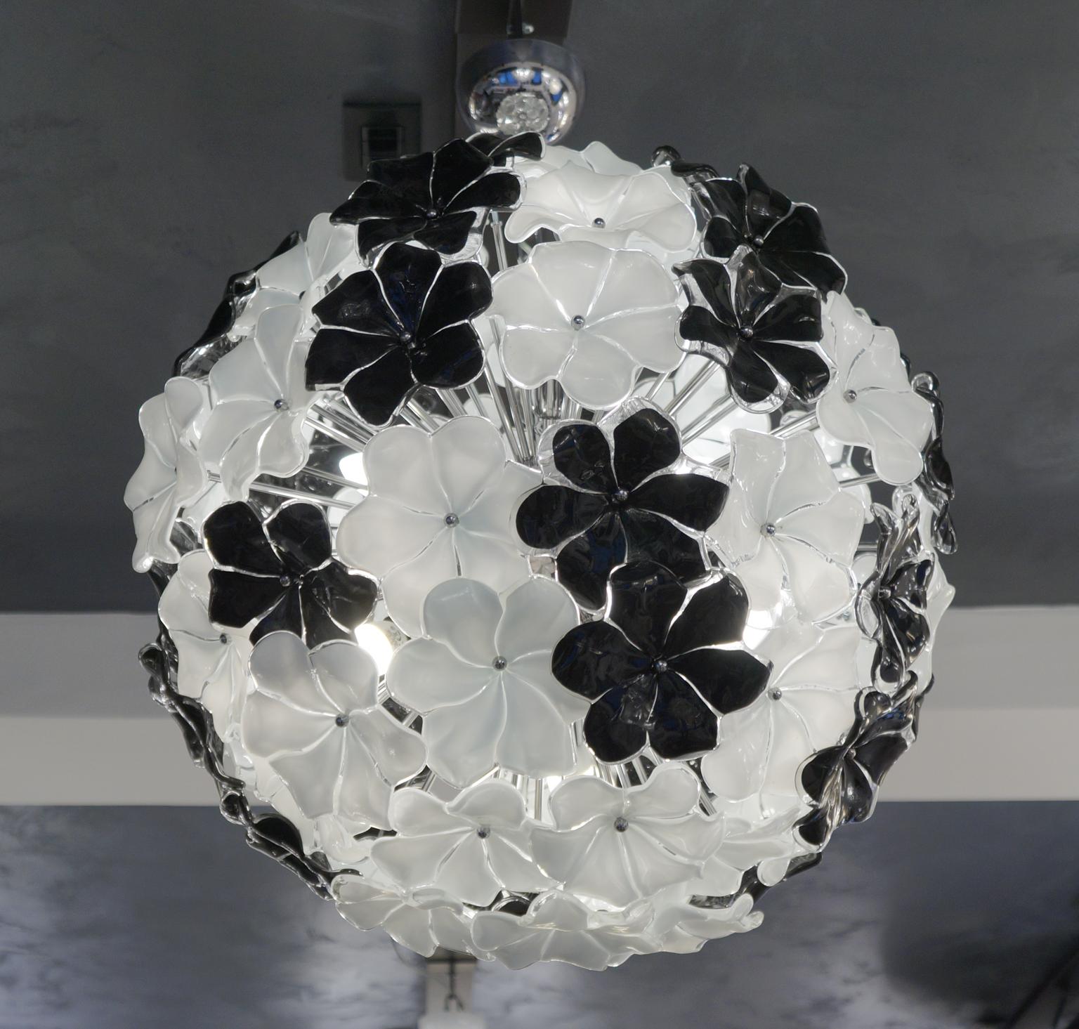 Exclusive flowers chandelier in Murano blown glass, black and white colour
Entirely worked by hand with extreme care and precision. Work performed by Alberto Donà in 1994. 
The chandelier contains 81 elements of flowers in Murano glass and six
