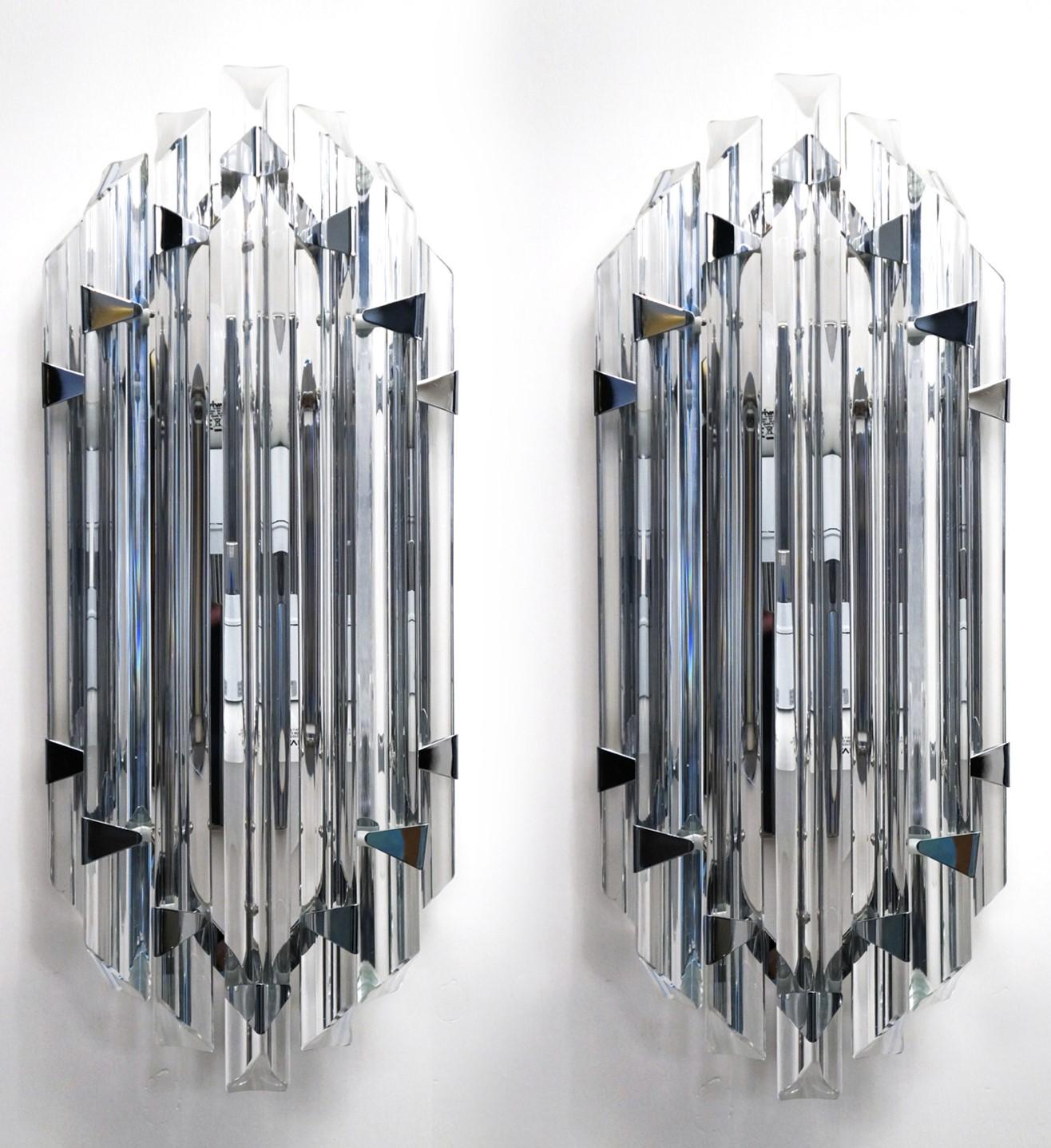 Eine sehr elegante Wandleuchte, die sieben Glaselemente präsentiert, die in das Glas gebogen sind, aber mit weichen und leichten Merkmalen, Farbe Kristall, gebogen sind. 
Entworfen von dem Meister Alberto Dona 'im Jahr 1990.

Die Produkte sind