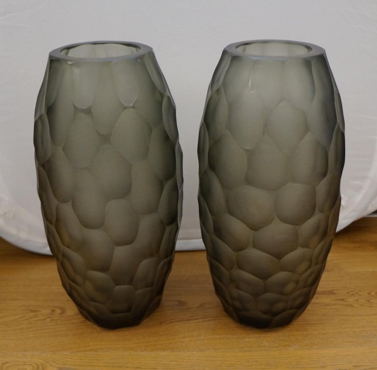 Two vases engraved entirely by hand with Murano grey blown glass.
To perform this work we need two different processes: the first, to model the hot vase giving form and color. The second, after cooling, it is taken into Moleria where the artists of