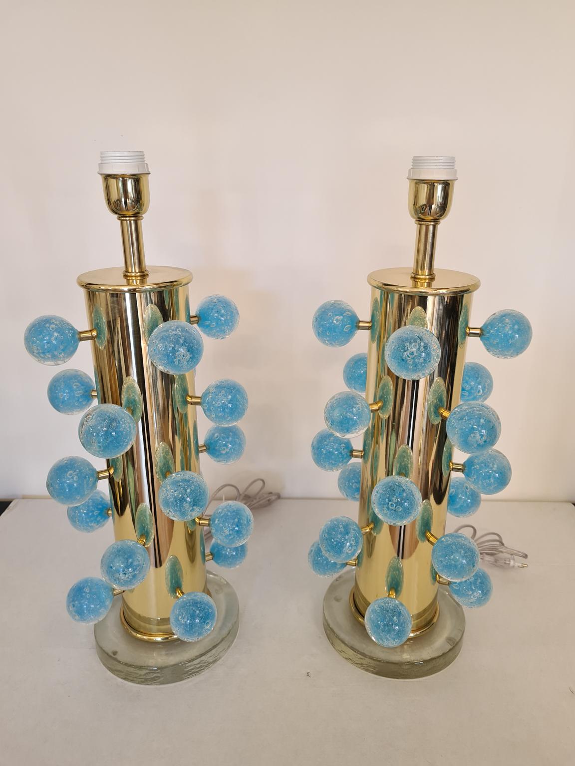 Exclusive pair of Murano glass table lamps with Pulegoso aquamarine spheres, transparent crystal base and gold chromed frame. 
Pulegoso processing are bubbles inside the color.
Lamp made with great care and precision by our master glassmaker