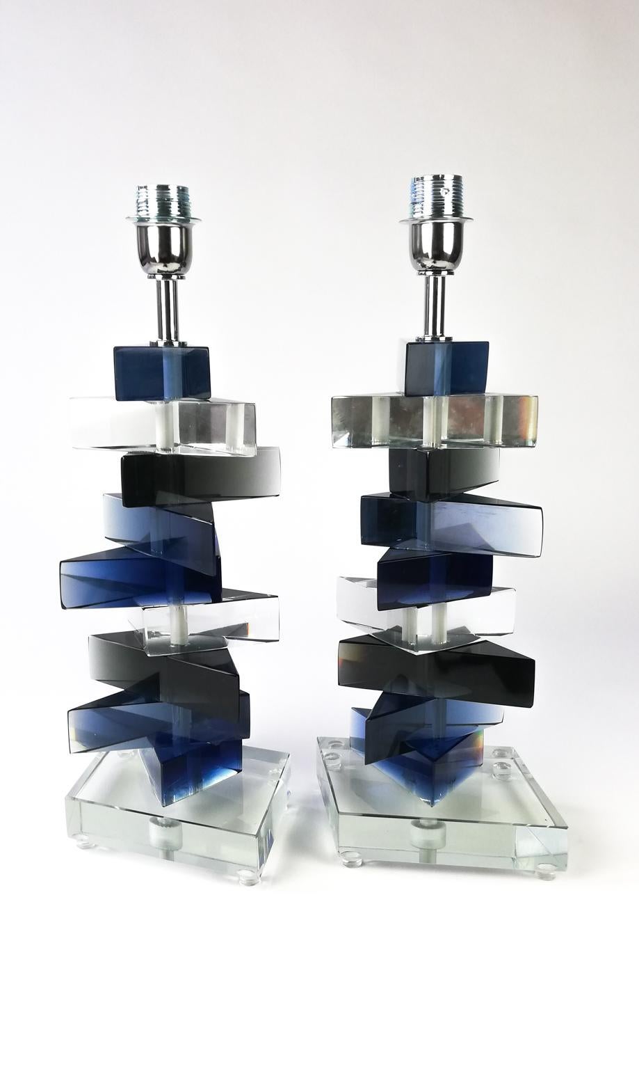 In 1985 Alberto Donà created a fabulous lamp with this product. He adds glass prisms of different colors, blue, grey and crystal.
The results are a fantastic table lamp that can reflect the light creating different and beautiful shades.
Every