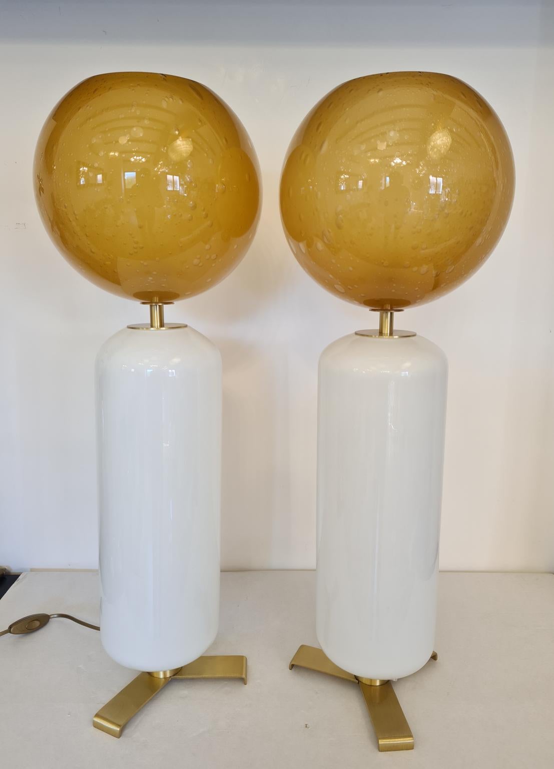 Exklusive Paar Murano Glas Tischlampen weiße Farbe mit Pulegoso Bernstein oberen Kugel.
Pulegoso Verarbeitung sind Blasen im Inneren der Farbe.
Die Lampe wurde mit großer Sorgfalt und Präzision von unserem Glasermeister Alberto Donà aus Murano