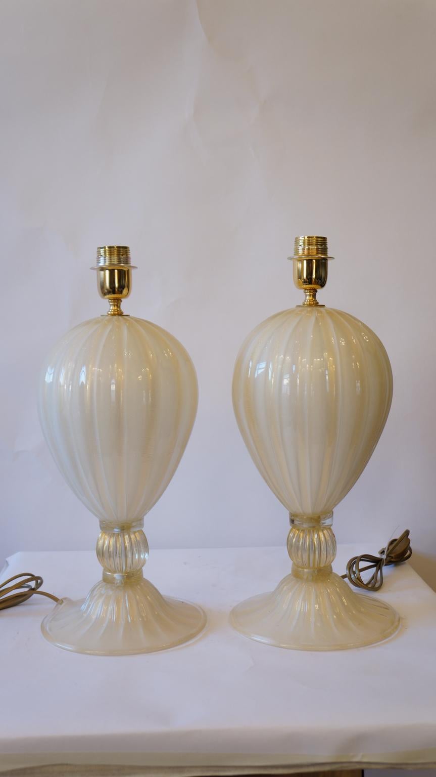 Exclusive pair of Murano glass table lamps white colour with details in 24 carat gold leaf.
By touching the lamps, you can hear the various grooves made especially by the 