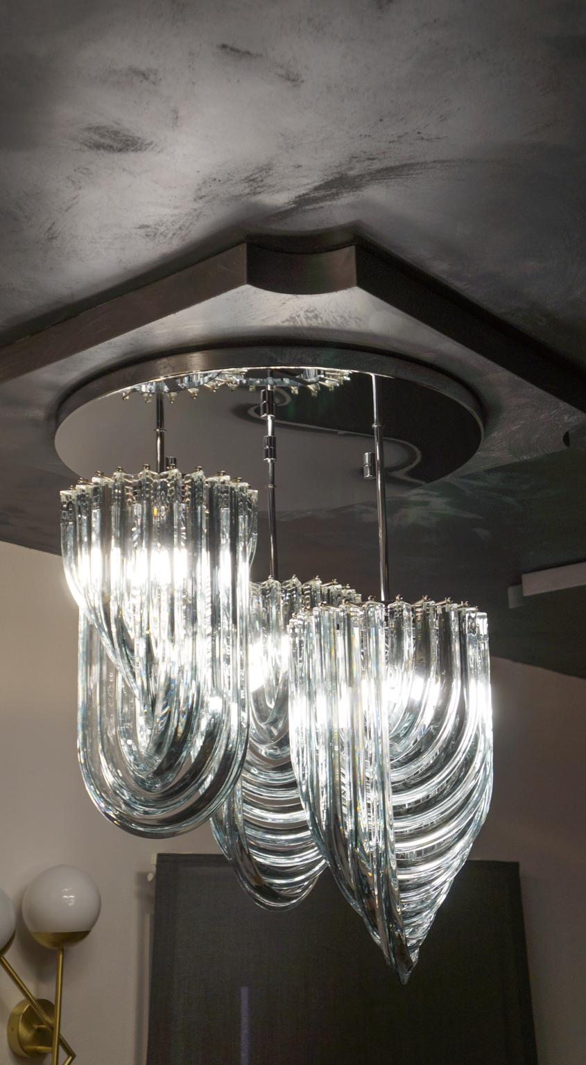 Murano blown glass chandelier with 33 crystal elements and the structure is in silver chrome.
This typical chandelier is the specialty of the Murano glass master Alberto Donà. The assistants take a small amount of glass from the oven. Being its