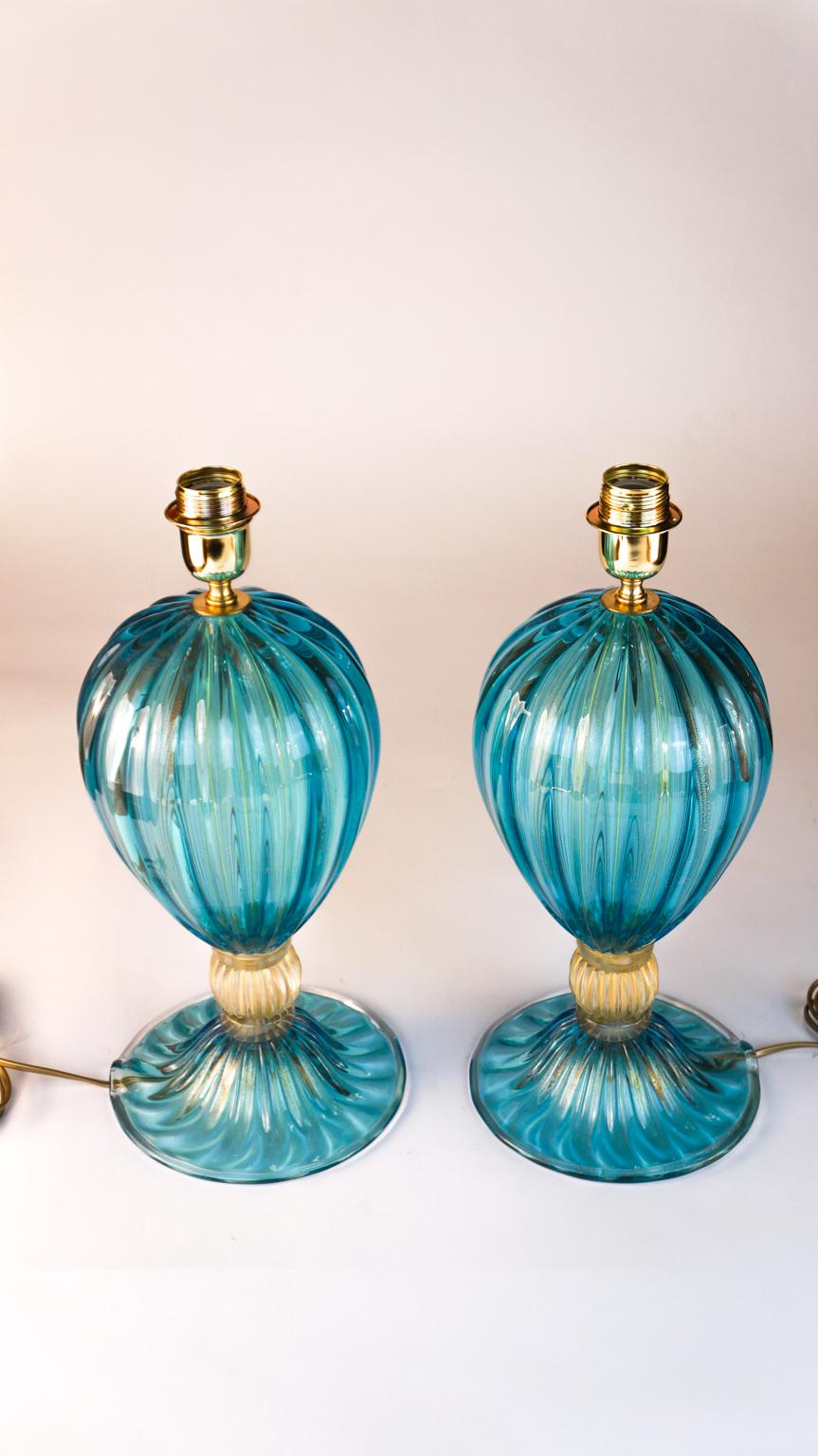 Exclusive pair of Murano glass table lamps aquamarine colour with details in 24 carat gold leaf.
By touching the lamps, you can hear the various grooves made especially by the 