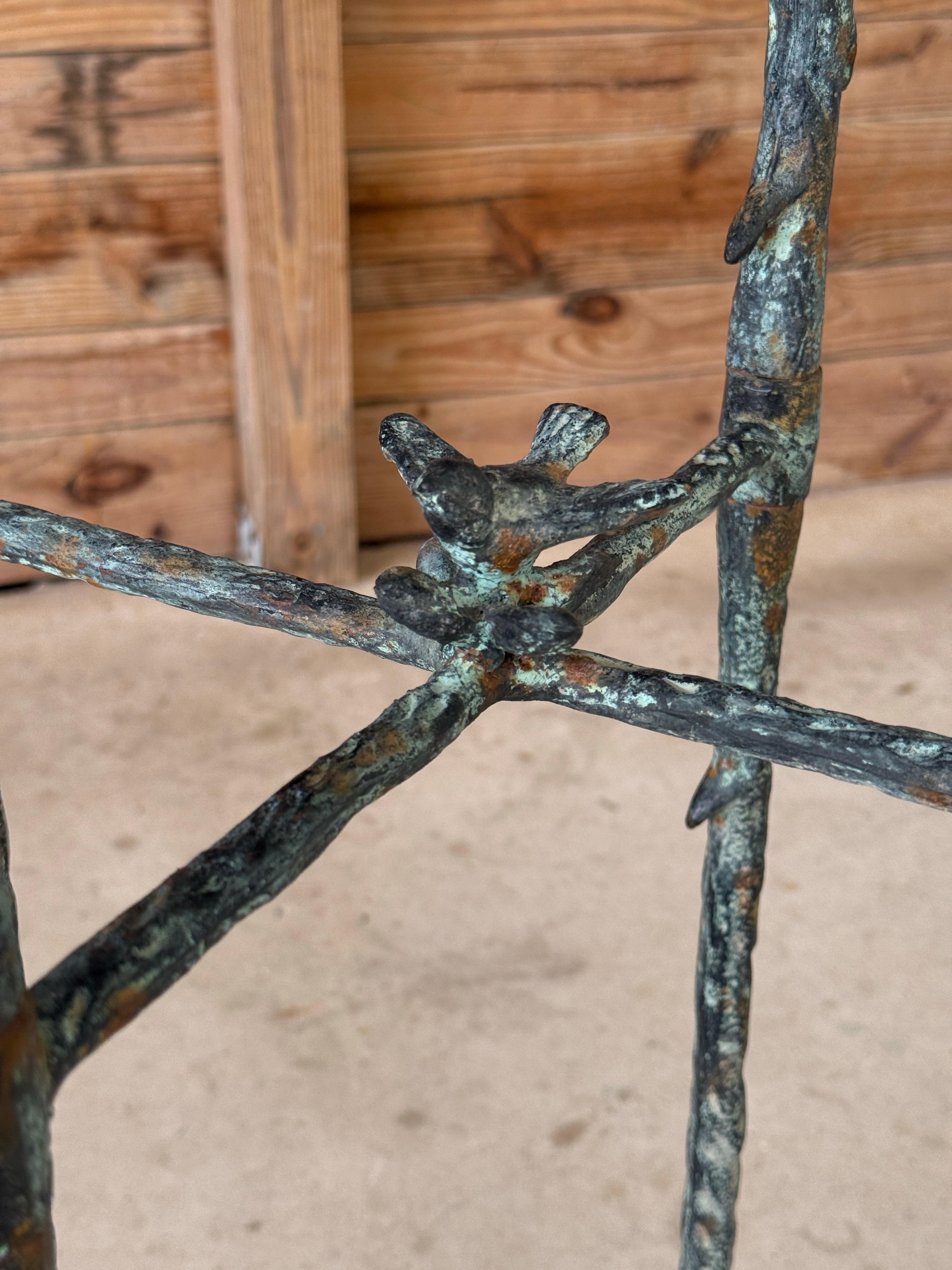 Un sorprendente e scultoreo supporto in metallo faux bois alla maniera di Alberto Giacometti, caratterizzato da una ricca patina verdastra e da un peso consistente. Progettato per imitare le forme organiche di rami e ramoscelli, questo pezzo evoca