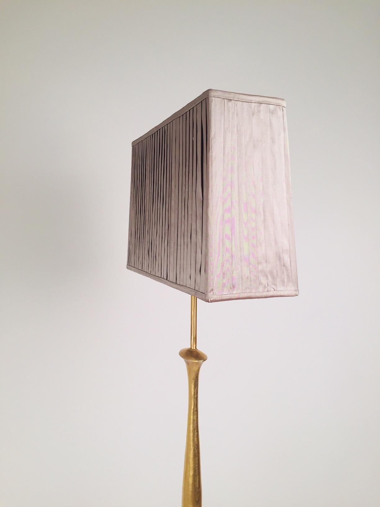 A 1960s brass floor lamp in the manner of Alberto Giacometti with grey folded shape.