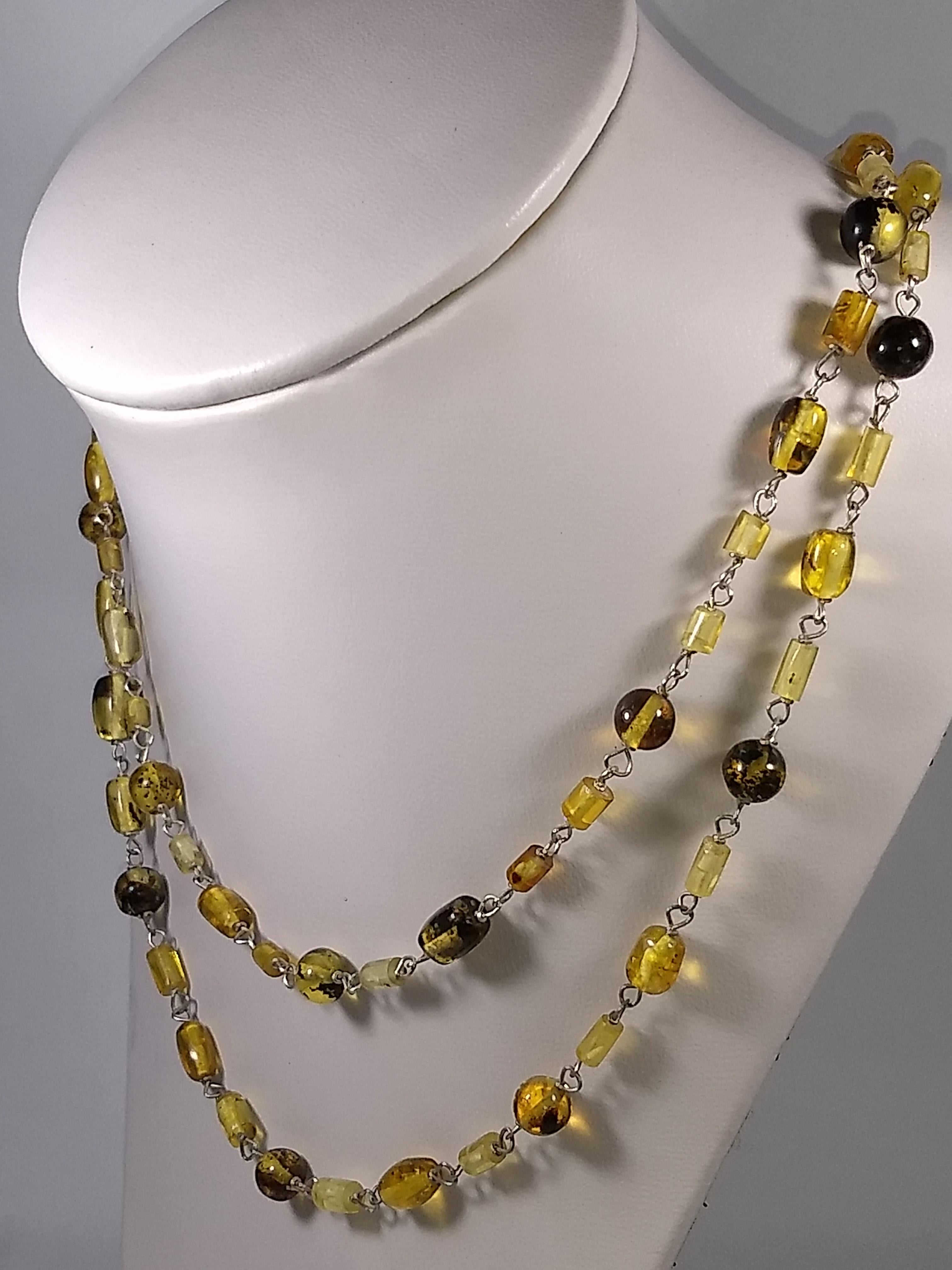 This Alberto Juan one of a kind necklace was handmade from sterling silver and orange and yellow amber. Amber beads are 22 carats. This necklace measures 43