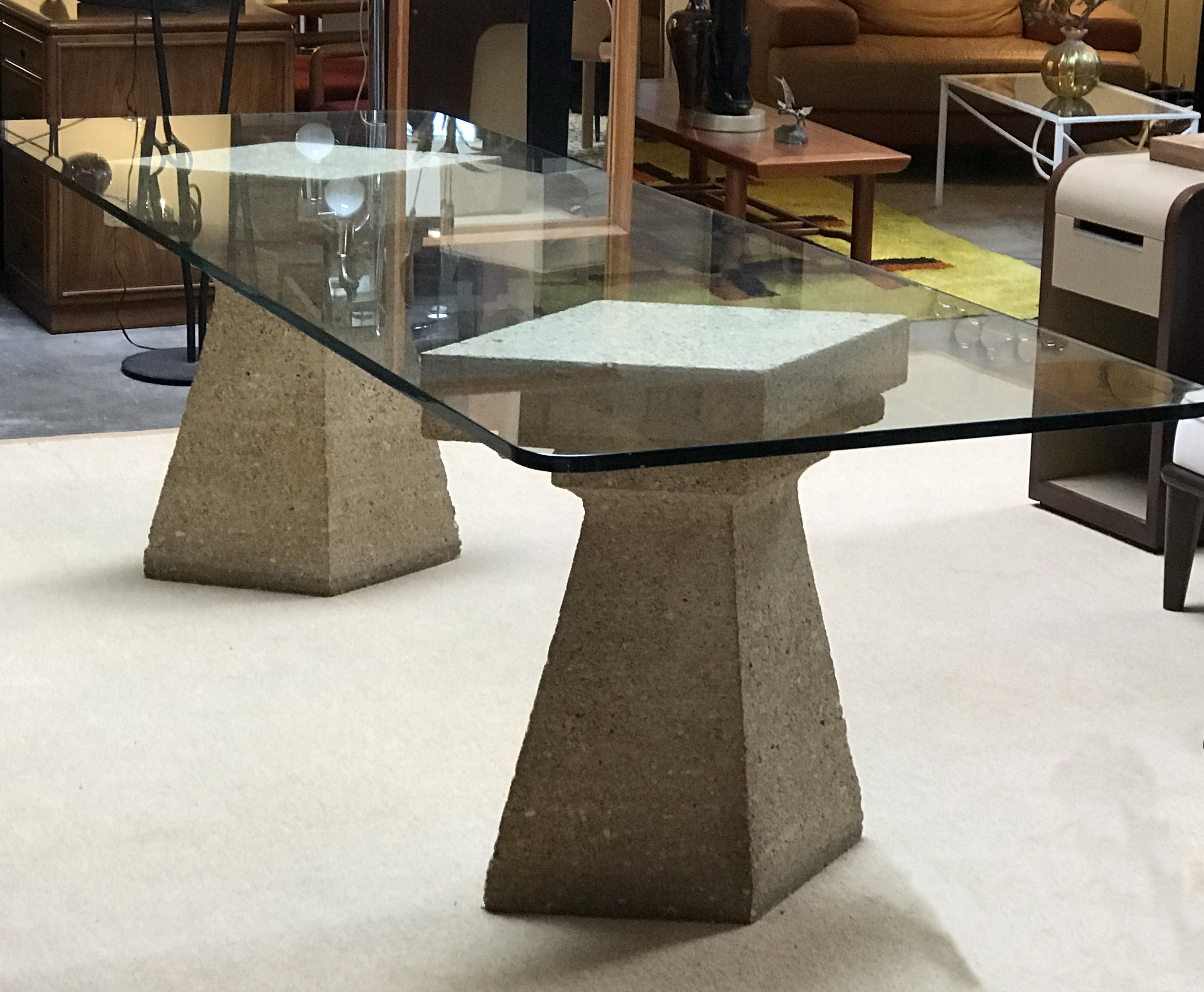 Stunning and unique glass table that rests on two stone lozenge-shaped pedestals.
The glass top has rounded corners and is 1