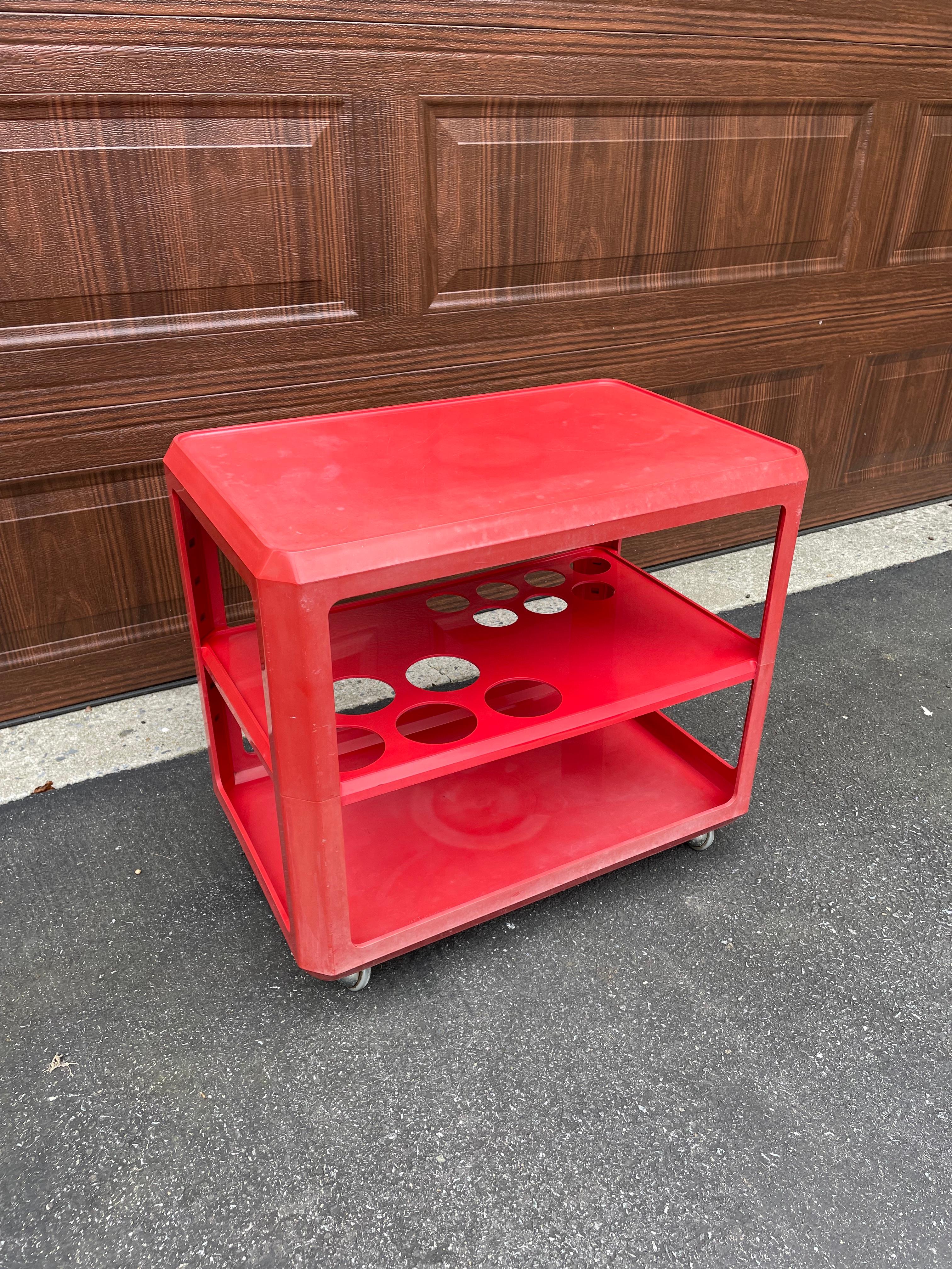 Fun and versatile drink trolley or bar cart by Alberto Roselli for Kartell. Likely 70's, this 'go-anywhere' workhorse would be great with mid century modern or Memphis decor. Candy apple red for a pop of color anywhere. This cart has lived a life