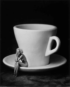 Lavazza-Kalender – Kaffeebecher mit Frau, die darauf sitzt, in Schwarz und Weiß